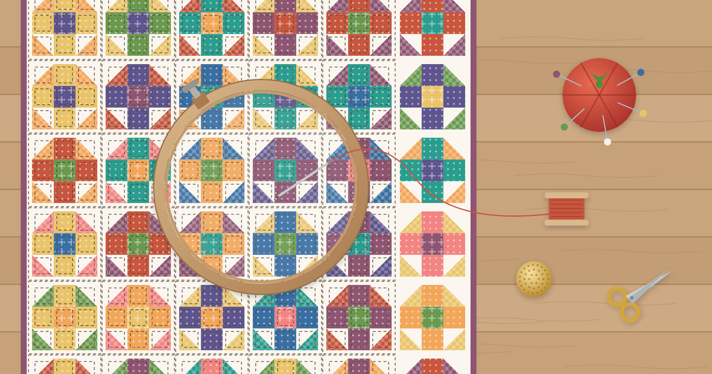 Patchwork quilt being hand quilted in a wooden hoop, with visible hand stitches, a needle and thread, a tomato pincushion, a thimble, and scissors on the table