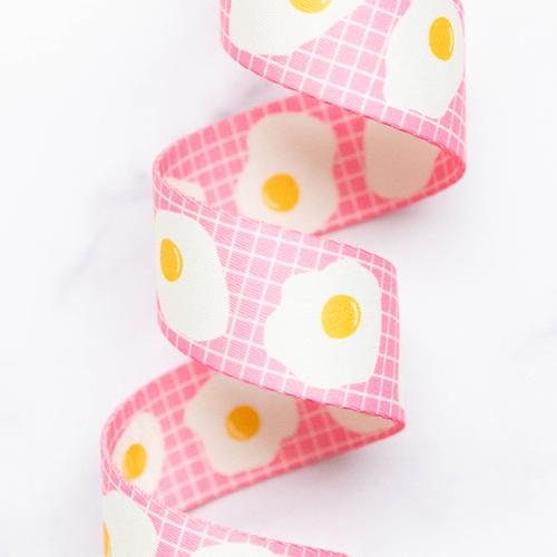 Fried Eggs in Pink 1.5-inch polyester webbing by Kimberly Kight featuring white fried eggs with yellow yolks on a pink grid background.