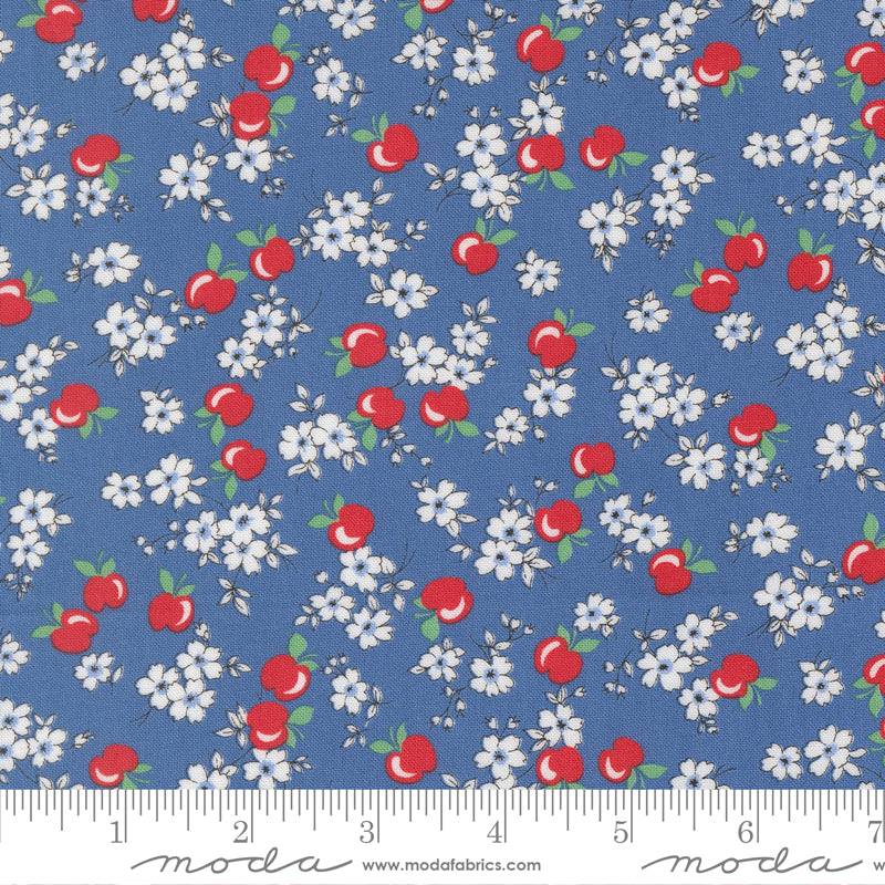 Close-up of 30s Playtime 2025 Apple Blossom Florals Bluebell Fabric by Linzee McCray for Moda Fabrics, showing red apples and white blossoms on a soft bluebell cotton background.