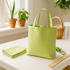 green gingham tote bag and matching napkins on a bright kitchen table with plants and sunlight.