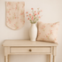 A cozy cottage-style table scene featuring Muse - Flower Picking Blush Fabric by 3 Sisters for Moda Fabrics, used as a table runner on a light wooden table with pink roses, soft sunlight, and sewing accessories creating a romantic vintage atmosphere.