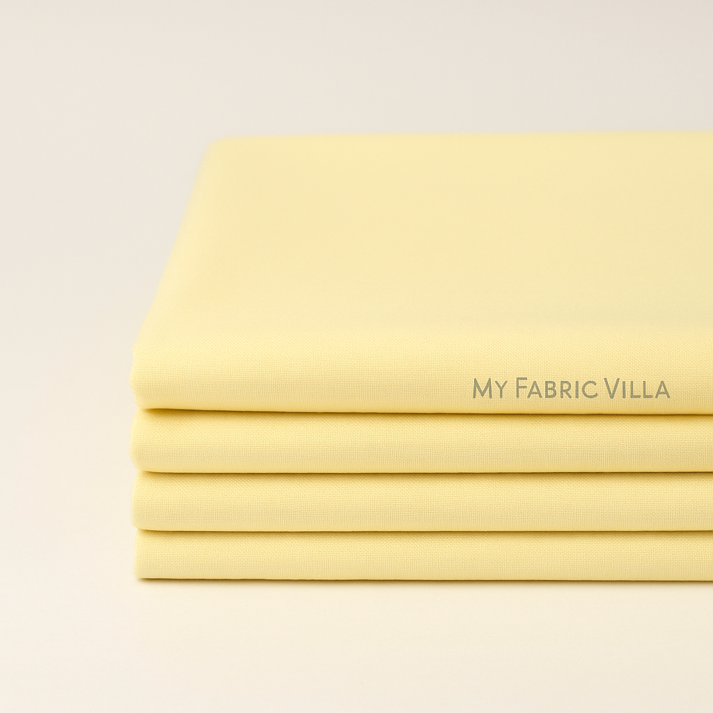 Folded stack of Bella Solids Baby Yellow Fabric by Moda Fabrics showing soft, colorfast cotton for quilting and sewing projects.