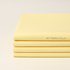 Folded stack of Bella Solids Baby Yellow Fabric by Moda Fabrics showing soft, colorfast cotton for quilting and sewing projects.
