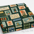 Folded stack of Holiday Stamps Evergreen Canvas Metallic Fabric by Rifle Paper Co. for Cotton + Steel showing metallic gold holiday postage designs.