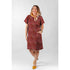 Woman wearing a short sleeve dress made with Tim Holtz Palette Red Tapestry cotton canvas fabric featuring vintage floral tapestry patterns in rich red, burgundy, olive green, and antique gold tones by FreeSpirit Fabrics.