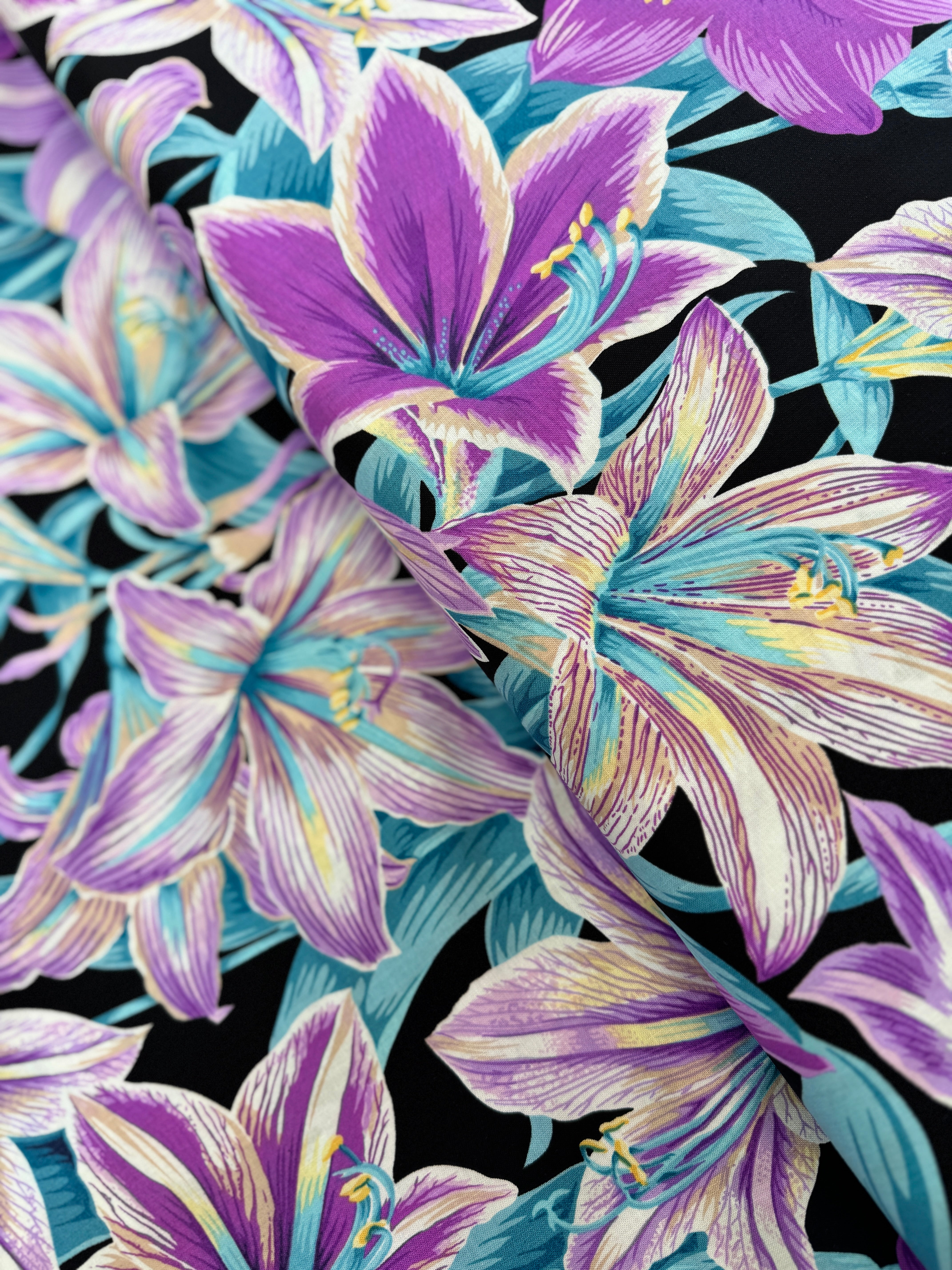 Kaffe Fassett Amaryllis Lavender polyester quilting cotton – lavender and teal amaryllis flowers on a black background, 44″ wide