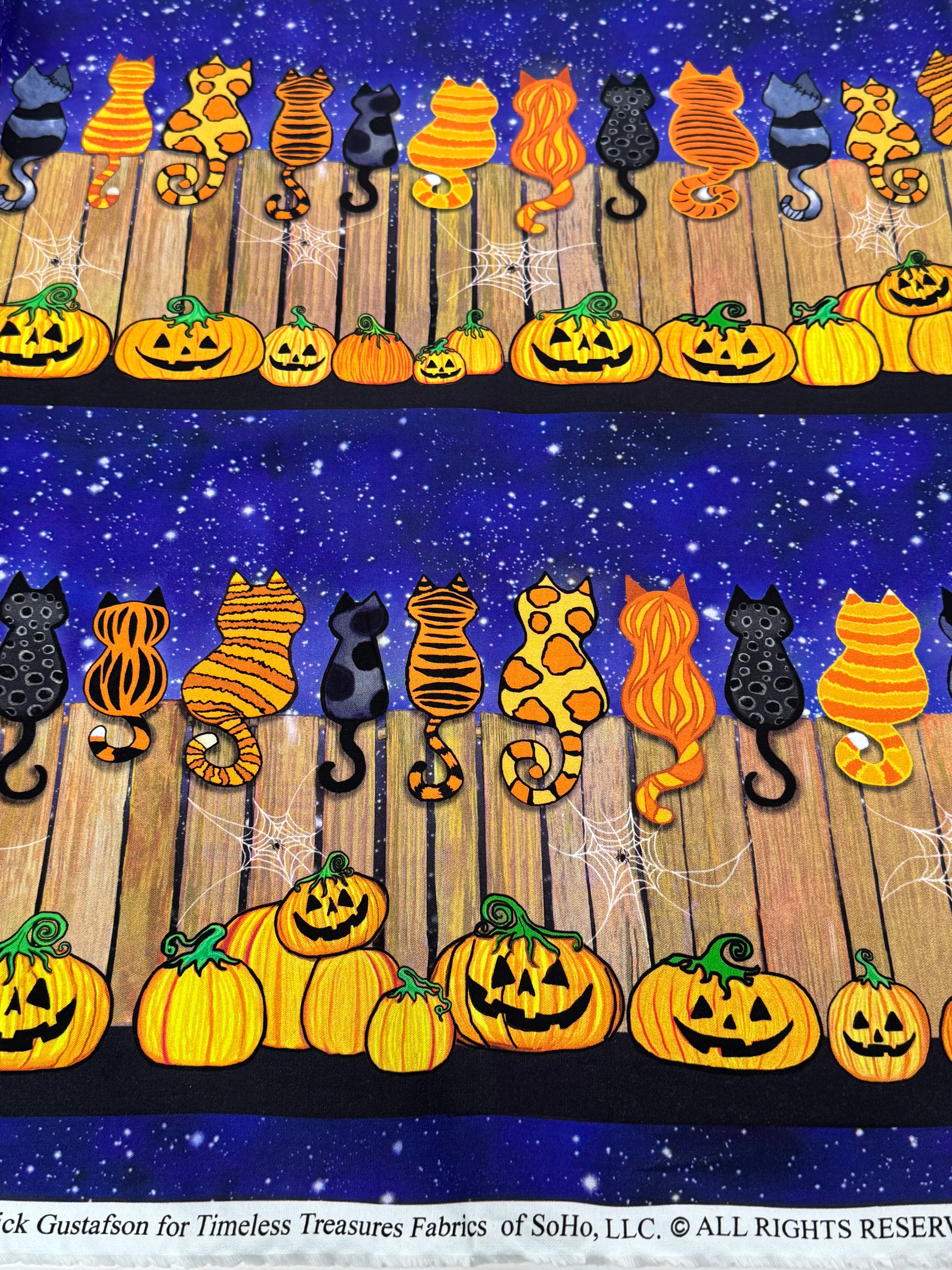 Feline Spooky Cats on Fence cotton fabric by Timeless Treasures featuring colorful Halloween cats, pumpkins, spider webs, and a rustic wooden fence.