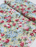 Floral cotton fabric featuring pink roses, blue hydrangeas, and delicate blossoms on a soft butter yellow background from the Simply Chic collection by Anna Stuart for Benartex.