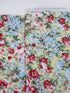 Floral cotton fabric featuring pink roses, blue hydrangeas, and delicate blossoms on a soft butter yellow background from the Simply Chic collection by Anna Stuart for Benartex.