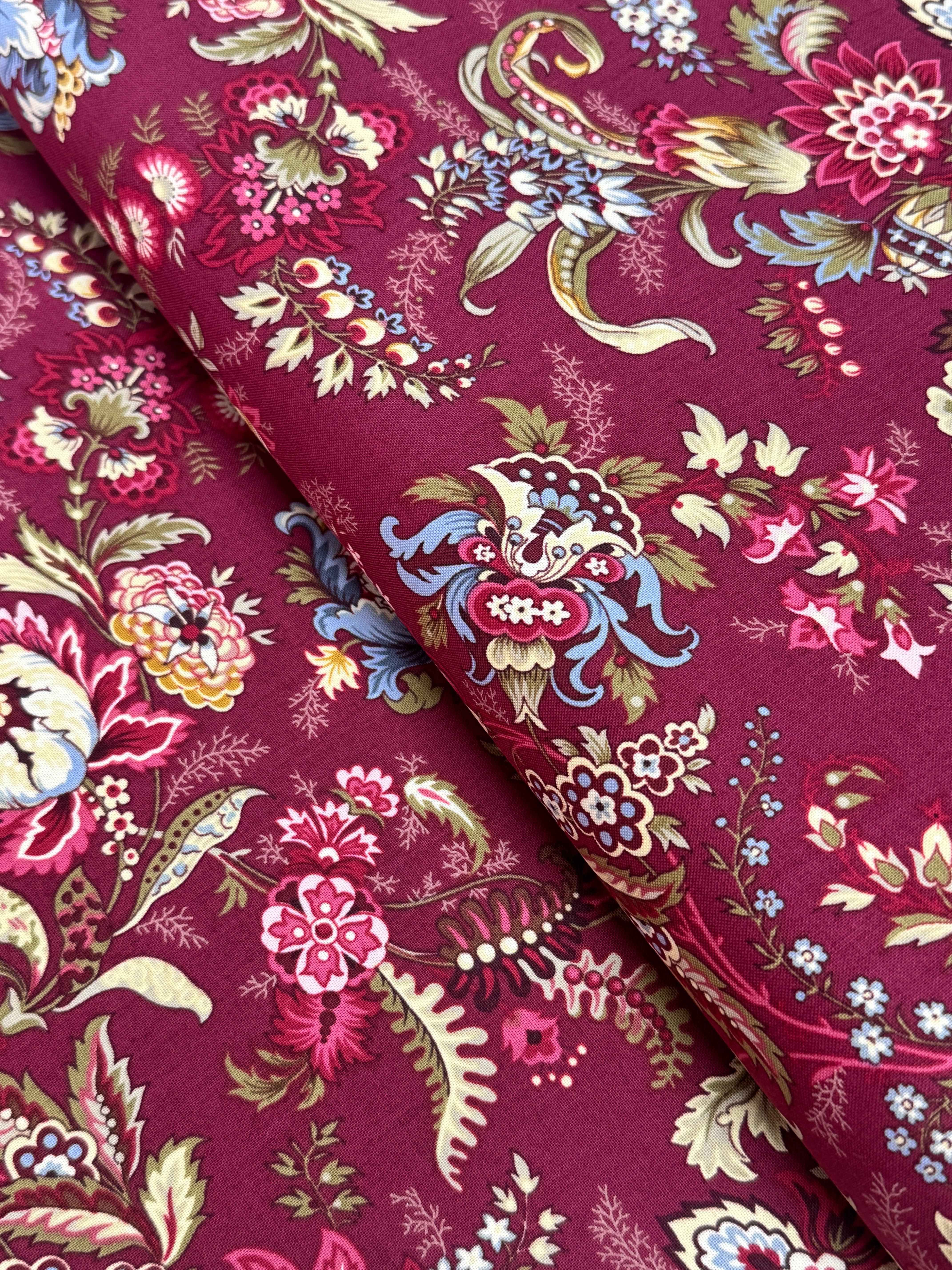 Marseille Red floral cotton fabric by Dover Hill for Benartex featuring ornate botanical flowers and foliage in burgundy, gold, cream, olive green, and blue on a rich red background.