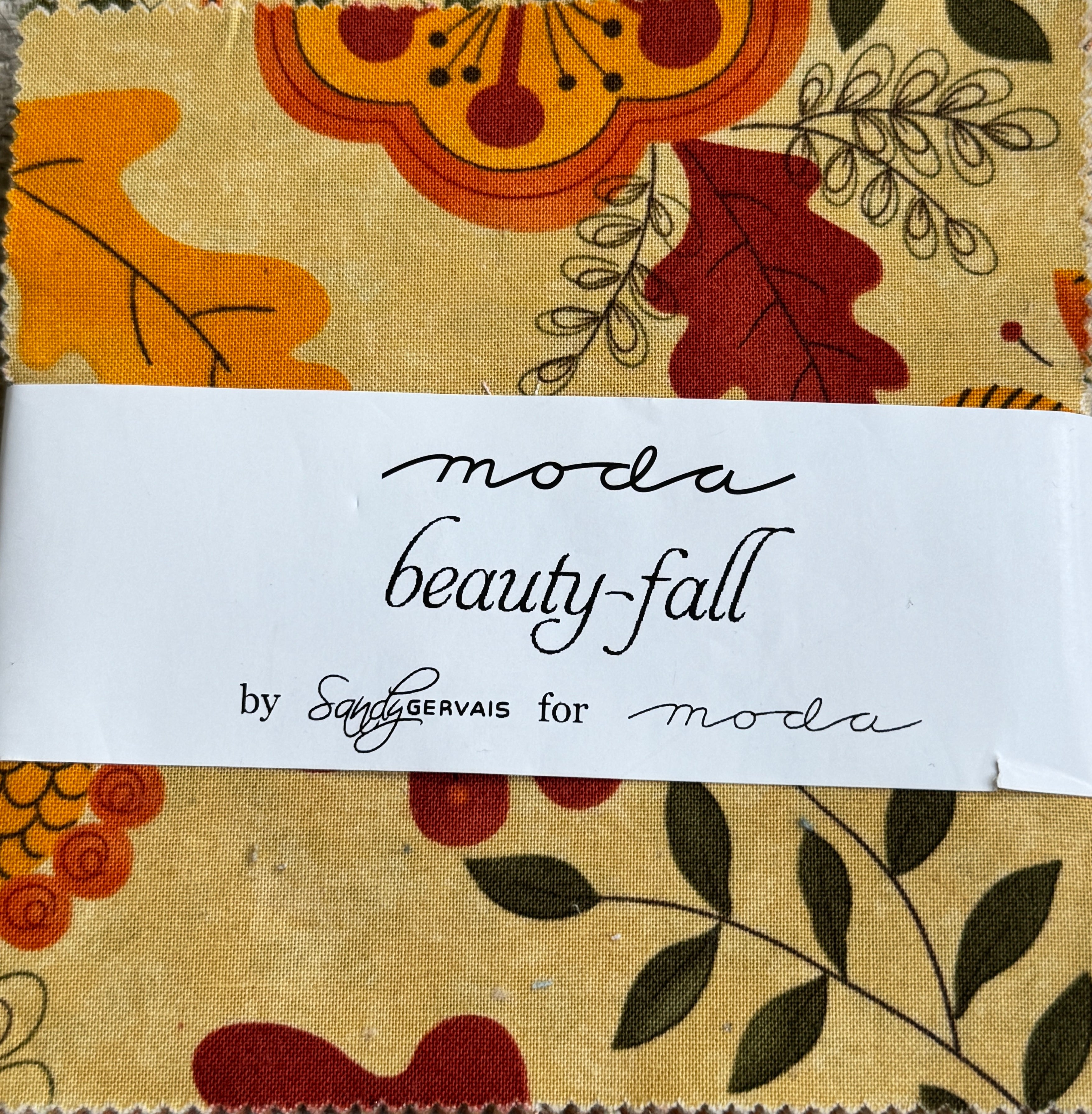Beauty-Fall Charm Pack by Sandy Gervais for Moda Fabrics featuring 42 coordinated 5-inch cotton fabric squares with autumn florals, leaves, berries, and seasonal prints in warm fall colors.