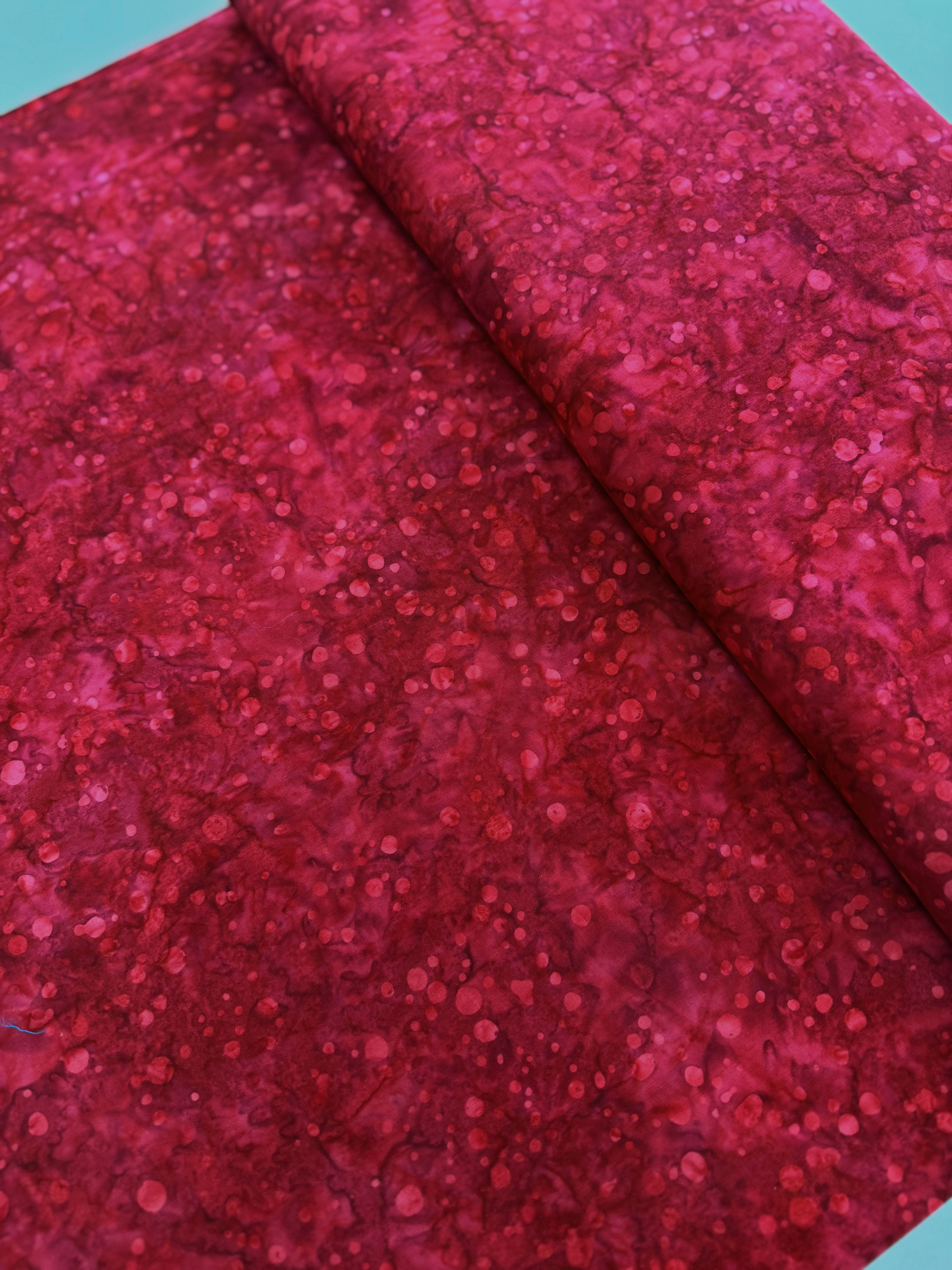 Blossom Batiks – Ink Dots – Cranberry fabric featuring subtle ink dot patterns in a rich cranberry hue by RJR Fabrics.