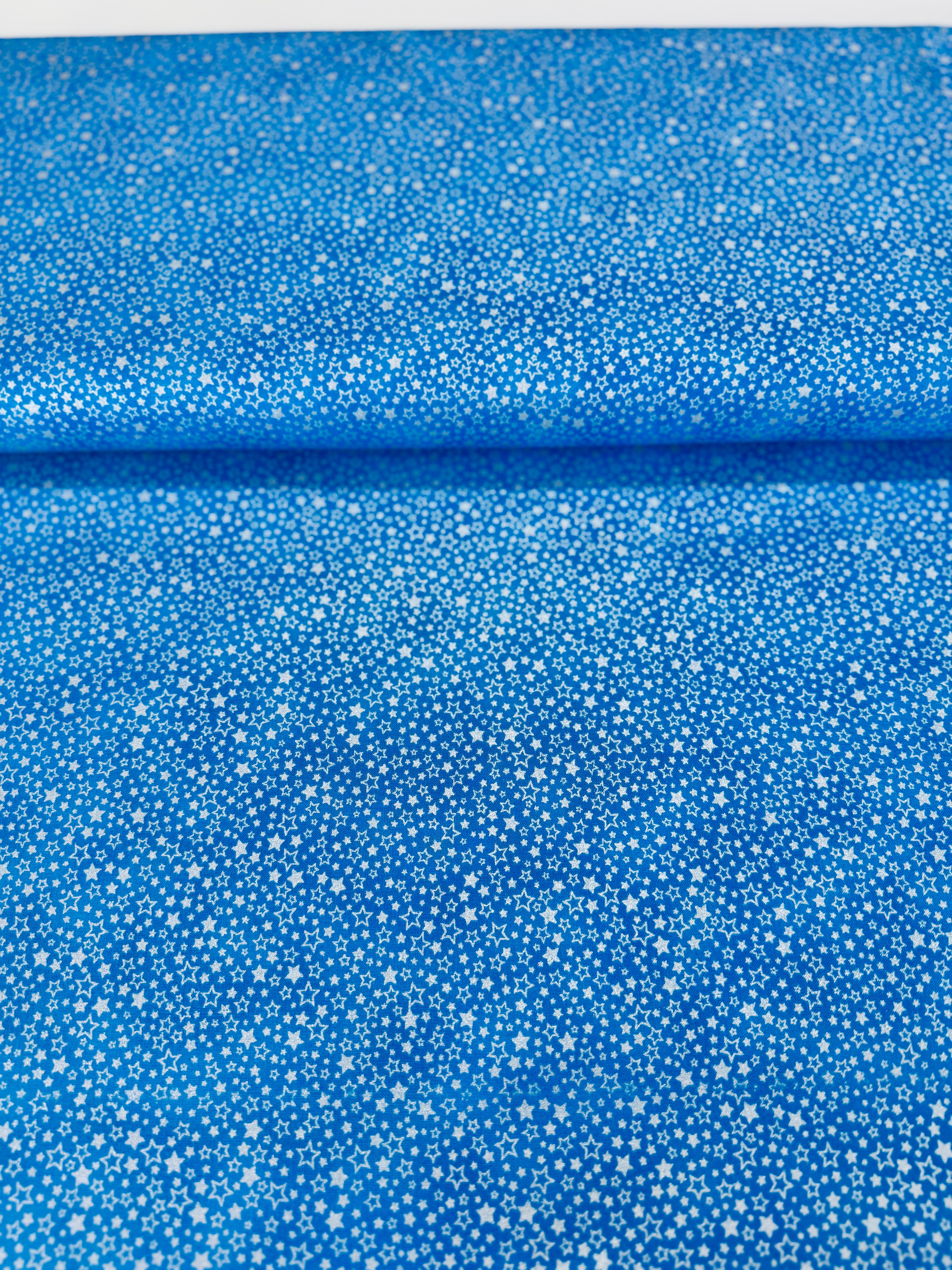 Holiday Charms fabric with silver stars on blue by Studio RK for Robert Kaufman.
