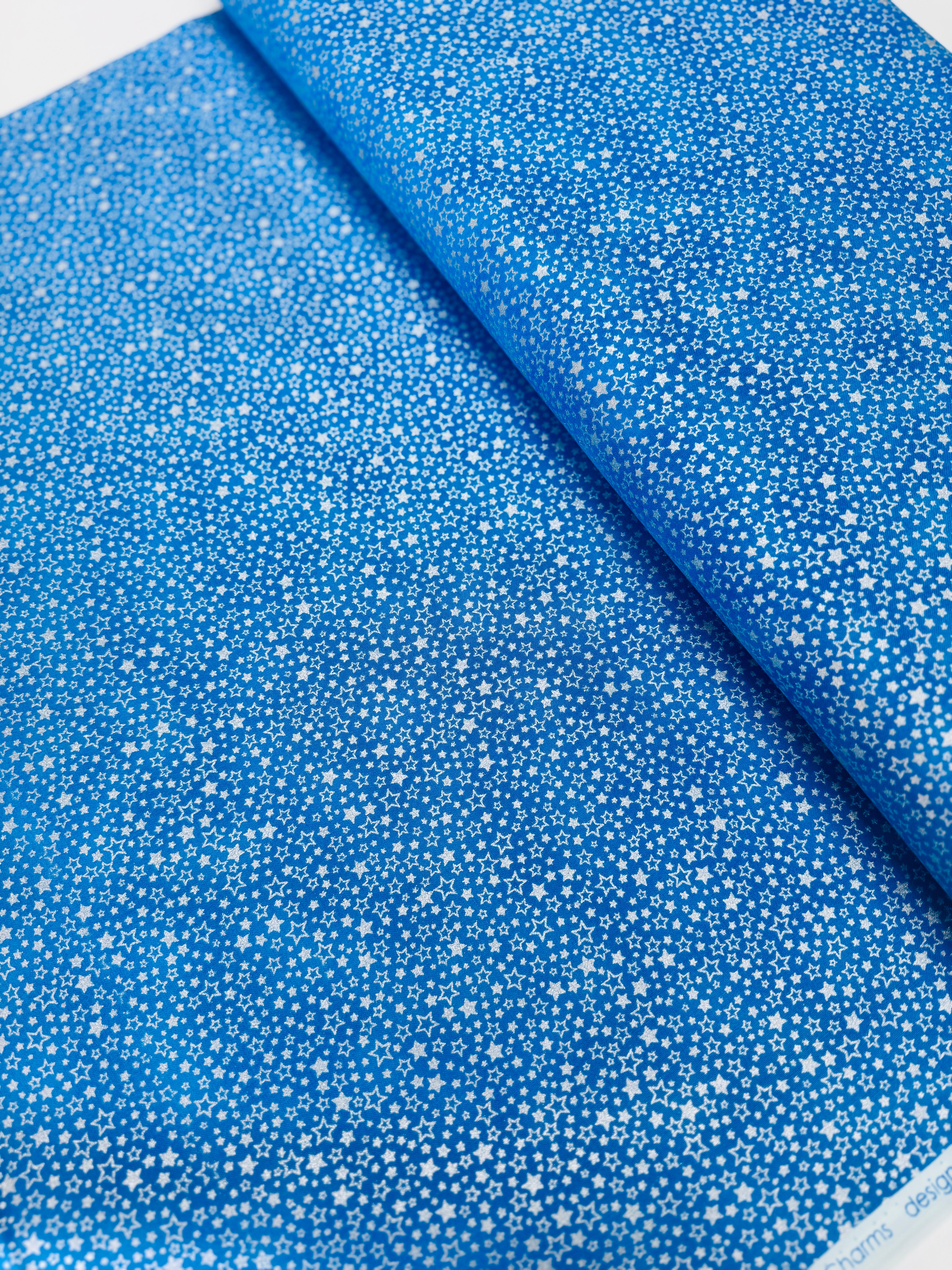 Holiday Charms fabric with silver stars on blue by Studio RK for Robert Kaufman.