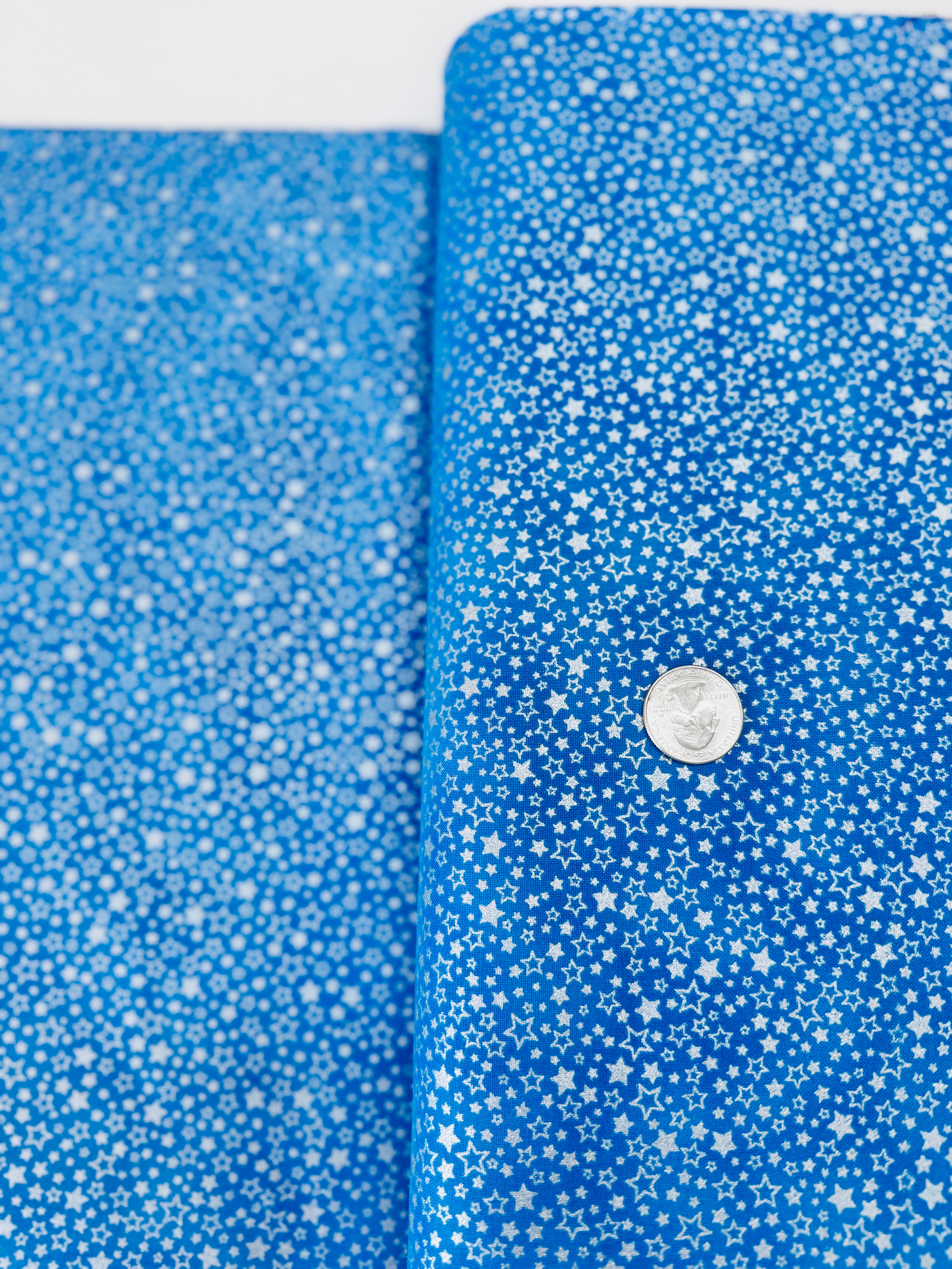 Holiday Charms fabric with silver stars on blue by Studio RK for Robert Kaufman.