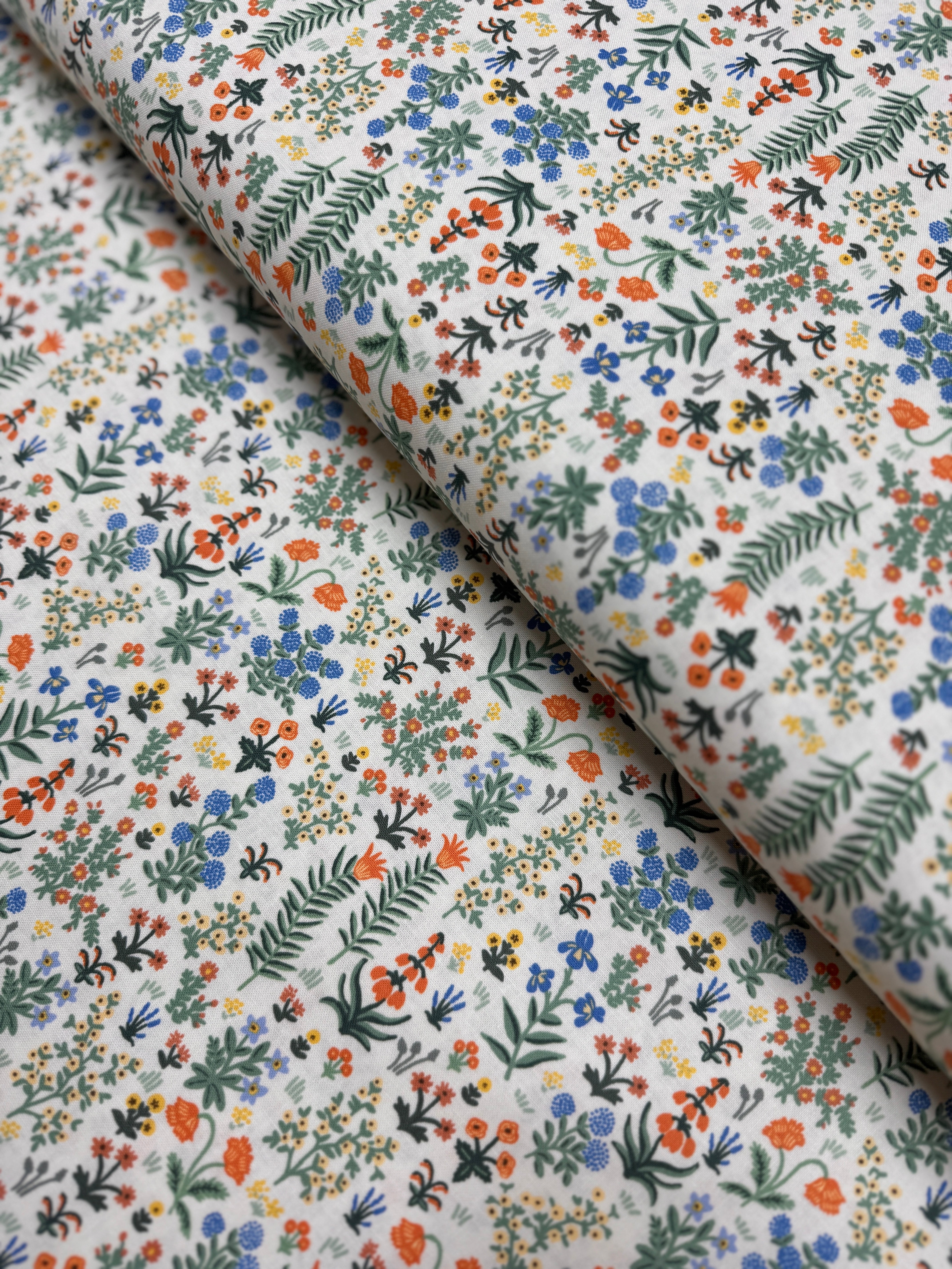 Camont Menagerie Garden Cream quilting cotton by Rifle Paper Co. for Cotton + Steel has flowers and fern like leaves on a cream background.