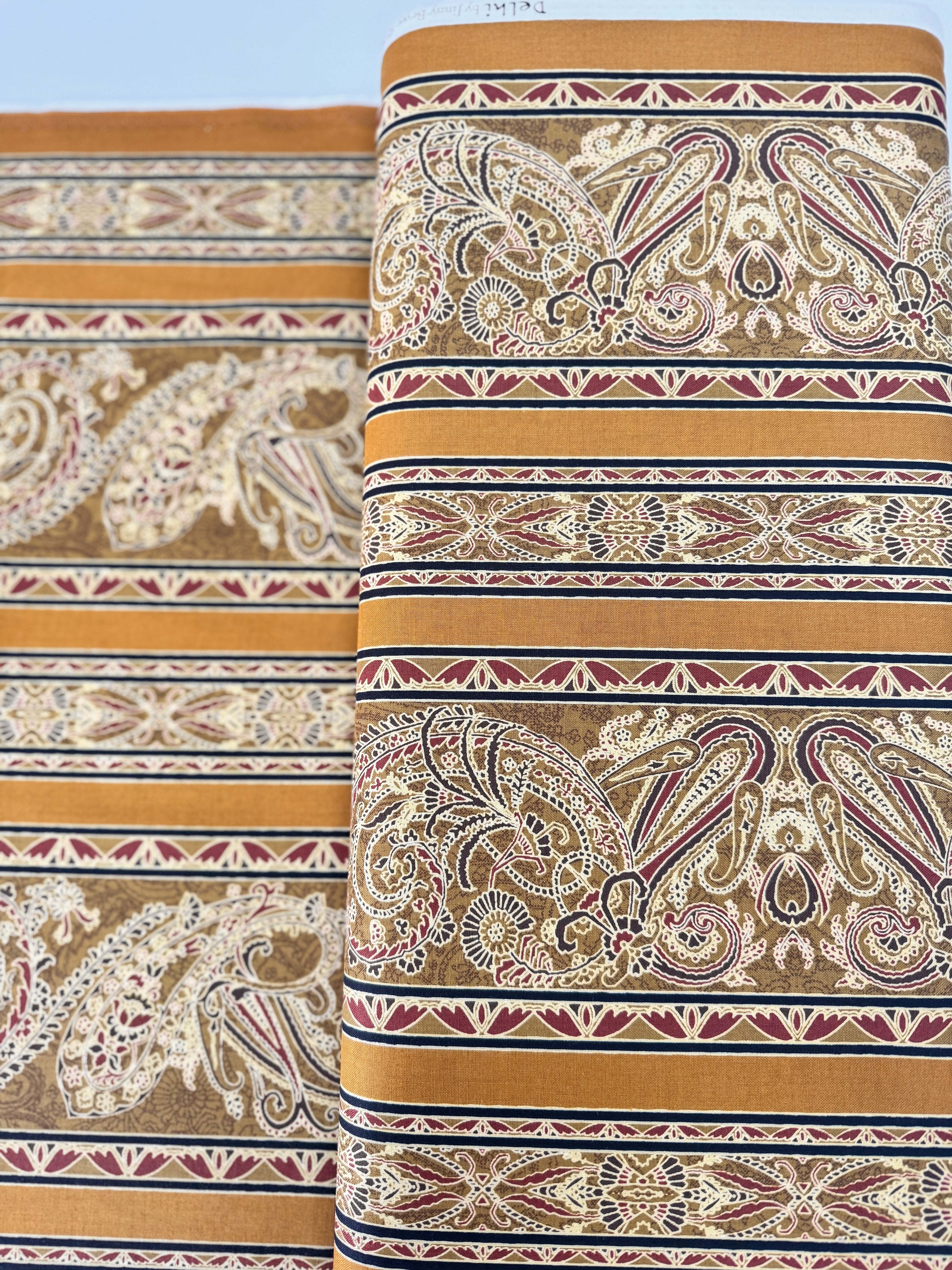 Delhi - Border Golden fabric by Jinny Beyer for RJR Fabrics with ornate Indian-style border design in rich golden tones on 100% cotton.