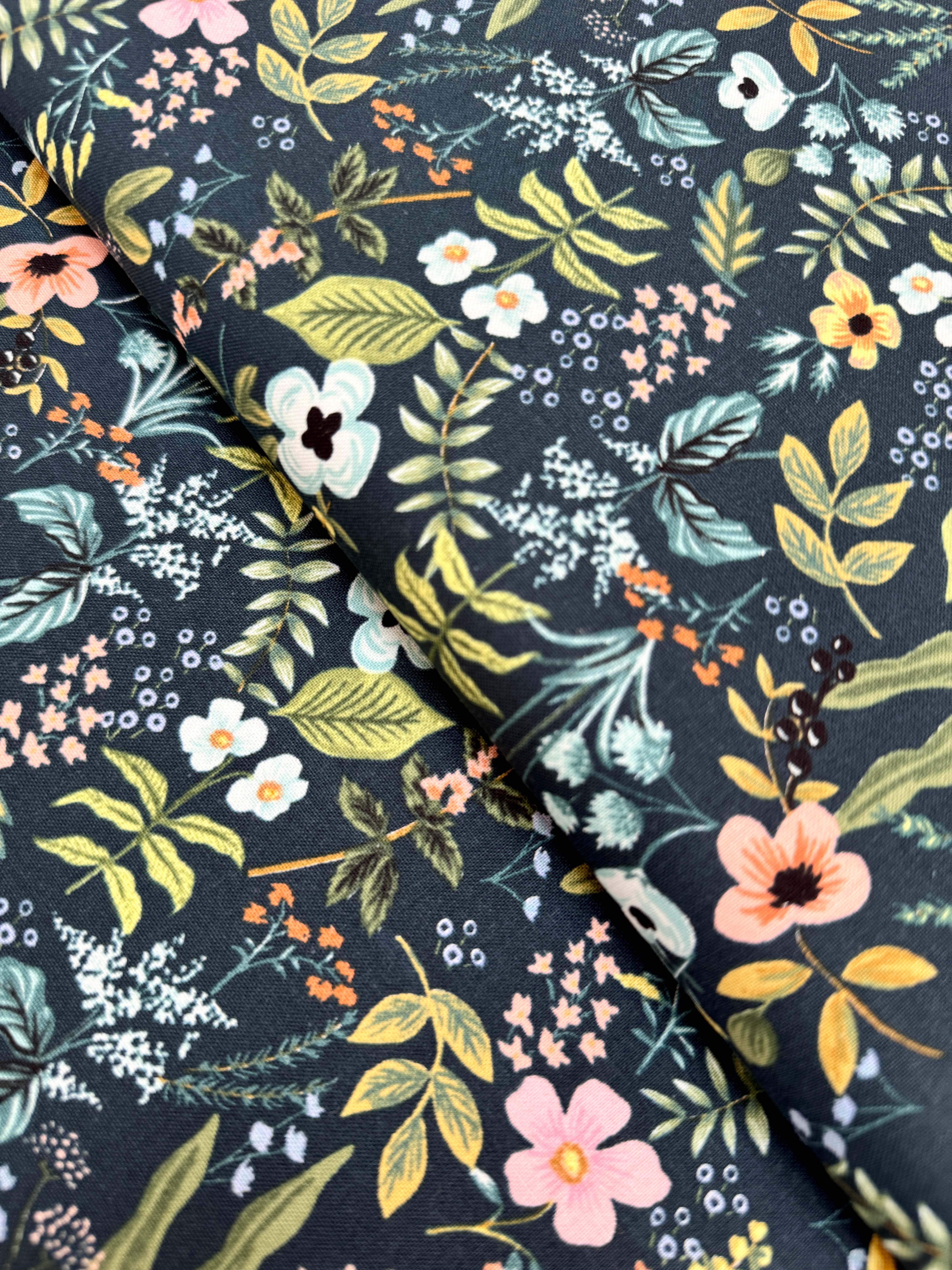 Amalfi Herb Garden Navy fabric by Rifle Paper Co. – bold floral print in pink, yellow, blue blooms with green leaves on navy background, 43″ wide