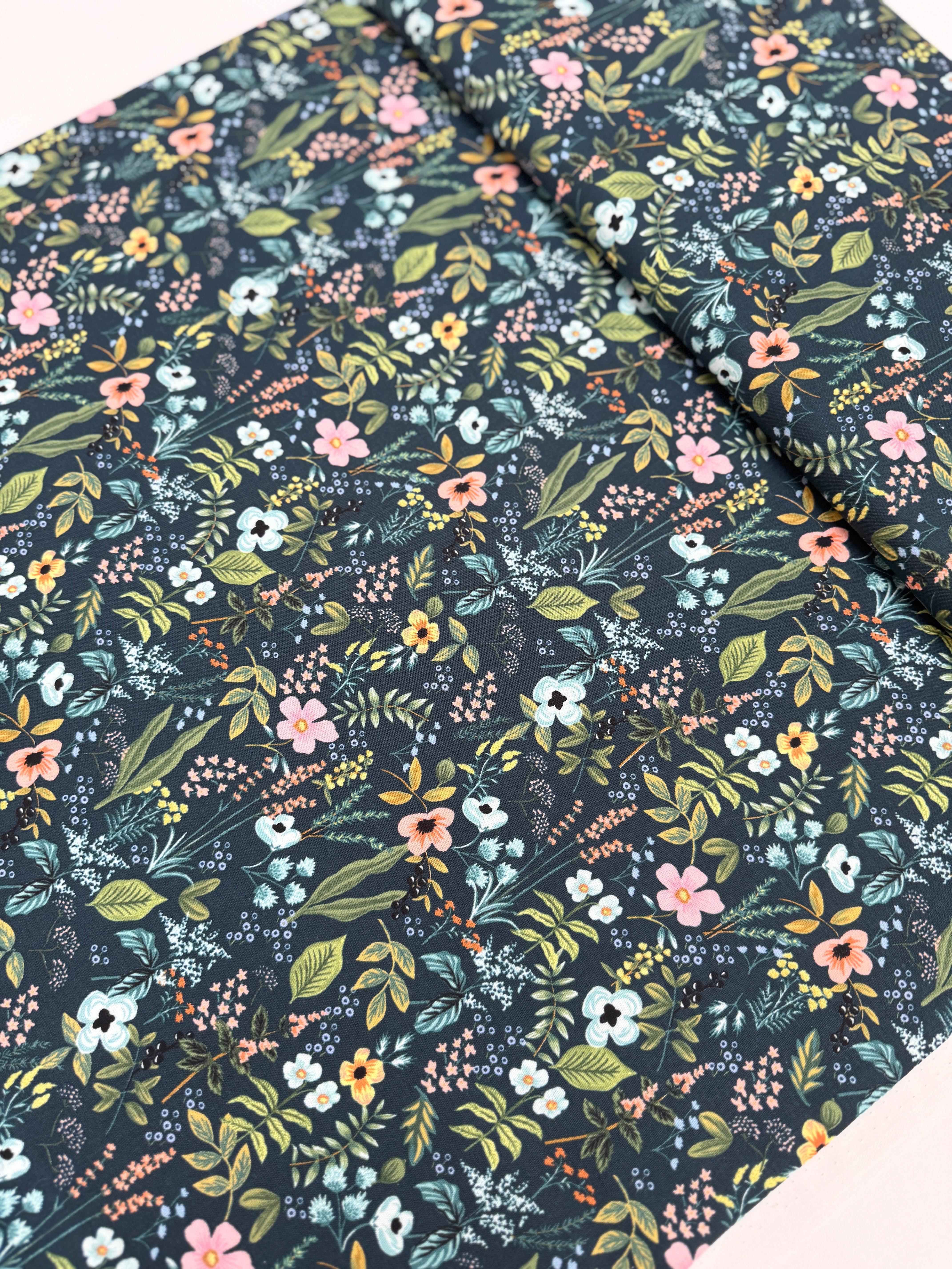 Amalfi Herb Garden Navy fabric by Rifle Paper Co. – bold floral print in pink, yellow, blue blooms with green leaves on navy background, 43″ wide