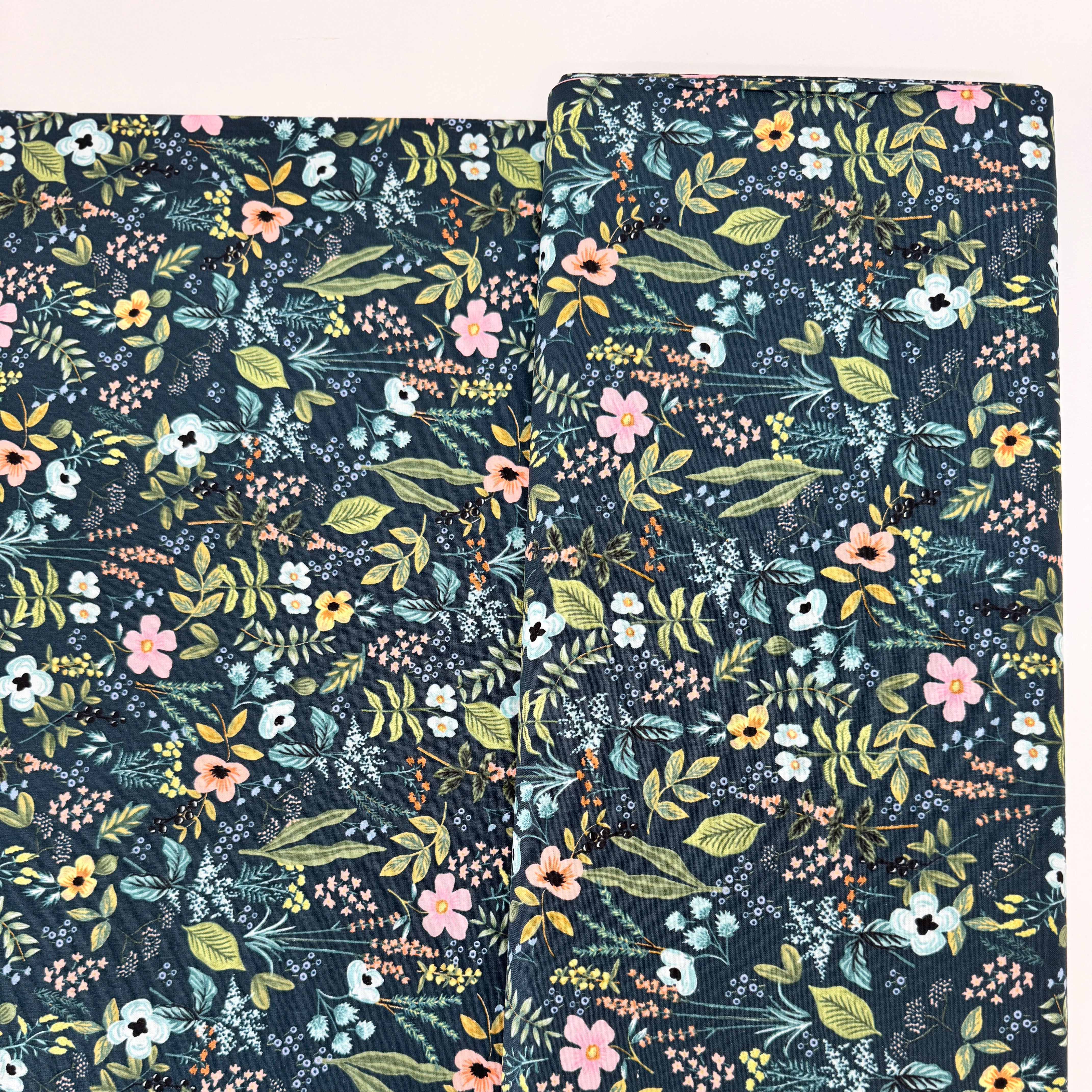 Amalfi Herb Garden Navy fabric by Rifle Paper Co. – bold floral print in pink, yellow, blue blooms with green leaves on navy background, 43″ wide