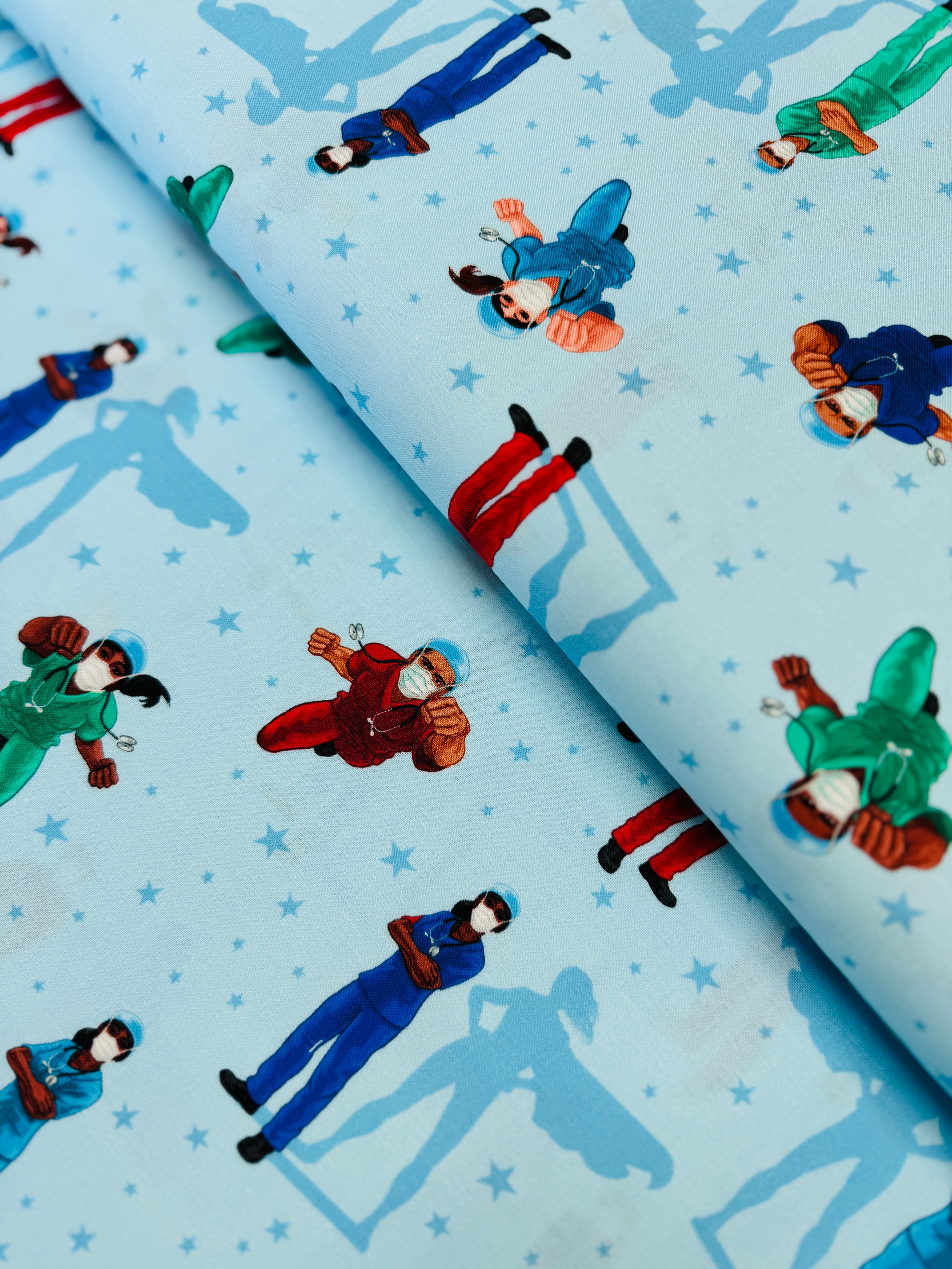 Frontline Heroes on Blue quilting cotton by Robert Kaufman – medical doctors and nurses motif on blue background, 43″ wide