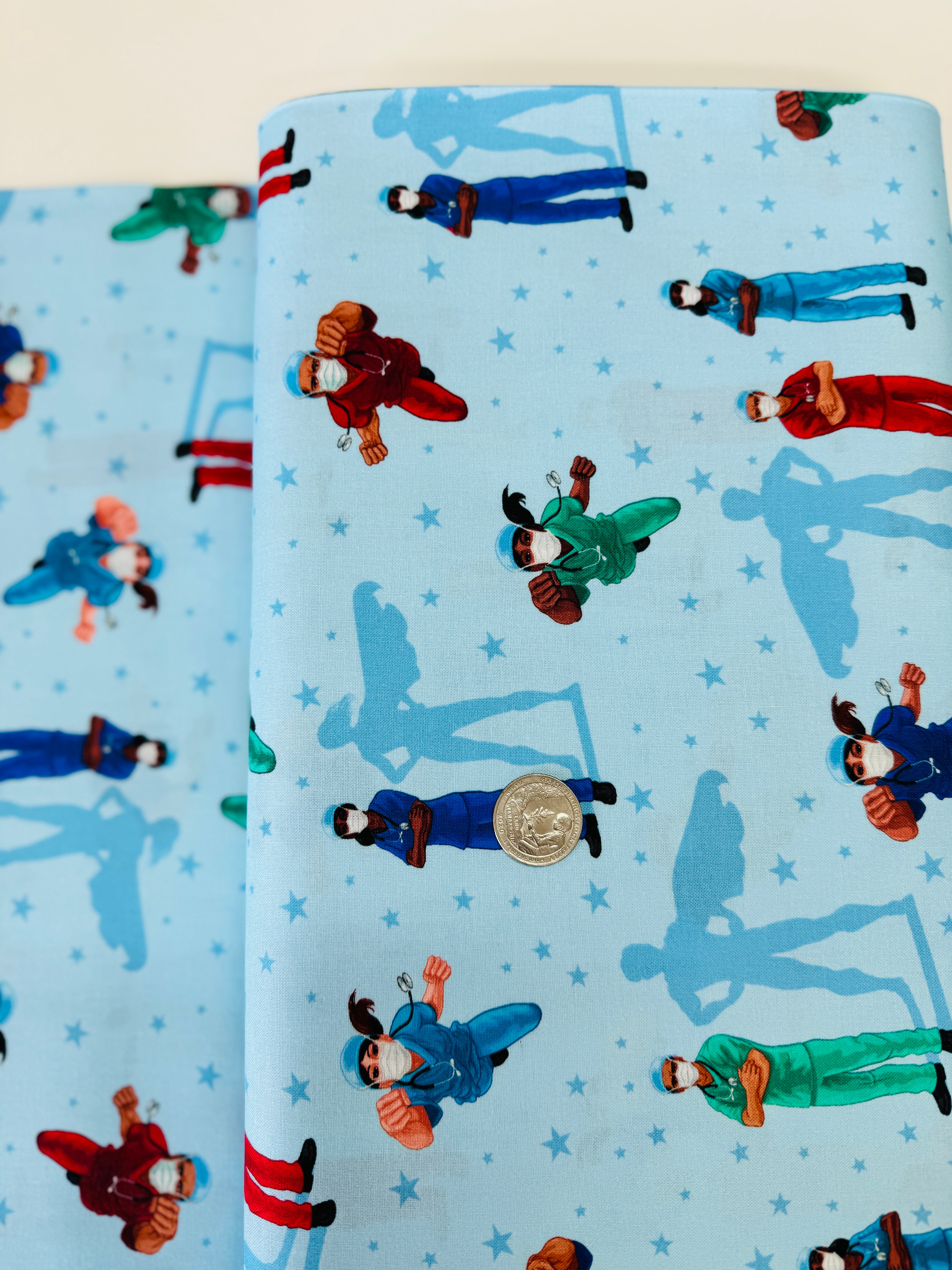Frontline Heroes on Blue quilting cotton by Robert Kaufman – medical doctors and nurses motif on blue background, 43″ wide