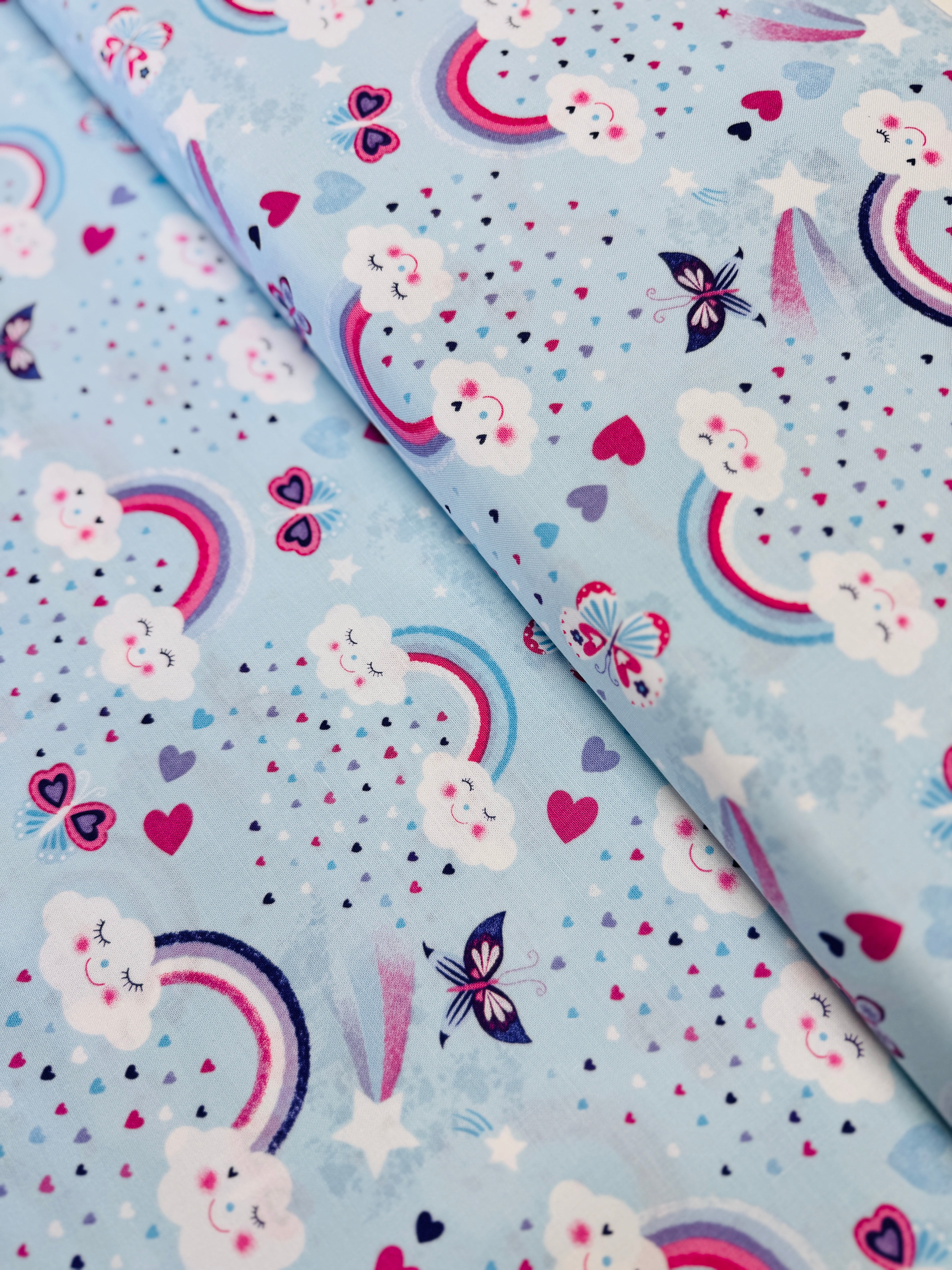 Unicorn Kisses Rainbow and Clouds cotton fabric by Studio E – cheerful rainbow and fluffy cloud motif on quilting cotton, 43″ wide
