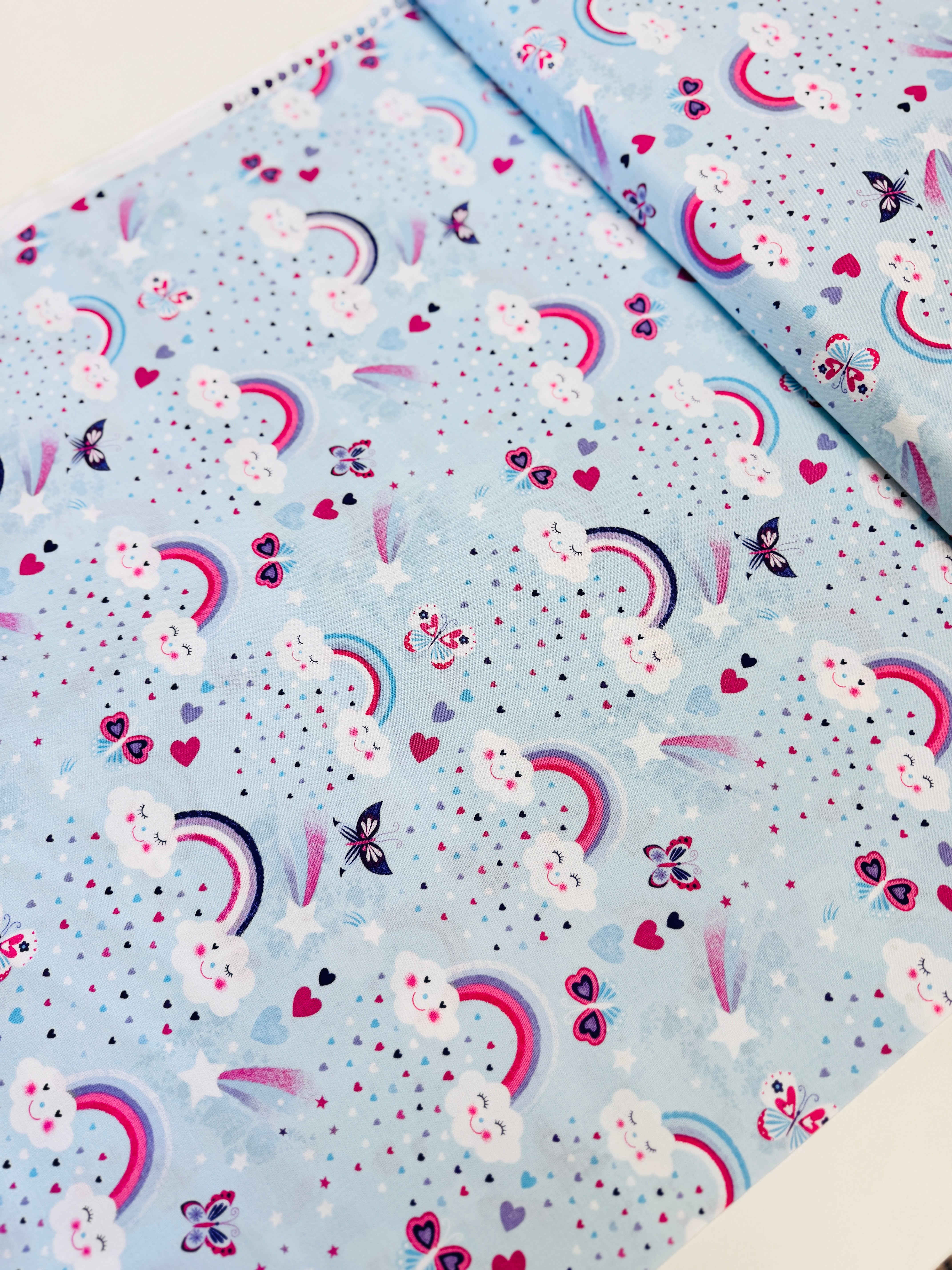 Unicorn Kisses Rainbow and Clouds cotton fabric by Studio E – cheerful rainbow and fluffy cloud motif on quilting cotton, 43″ wide