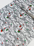 White cotton fabric with skeleton dinosaur T‑Rex prints wearing Santa hats and holding presents