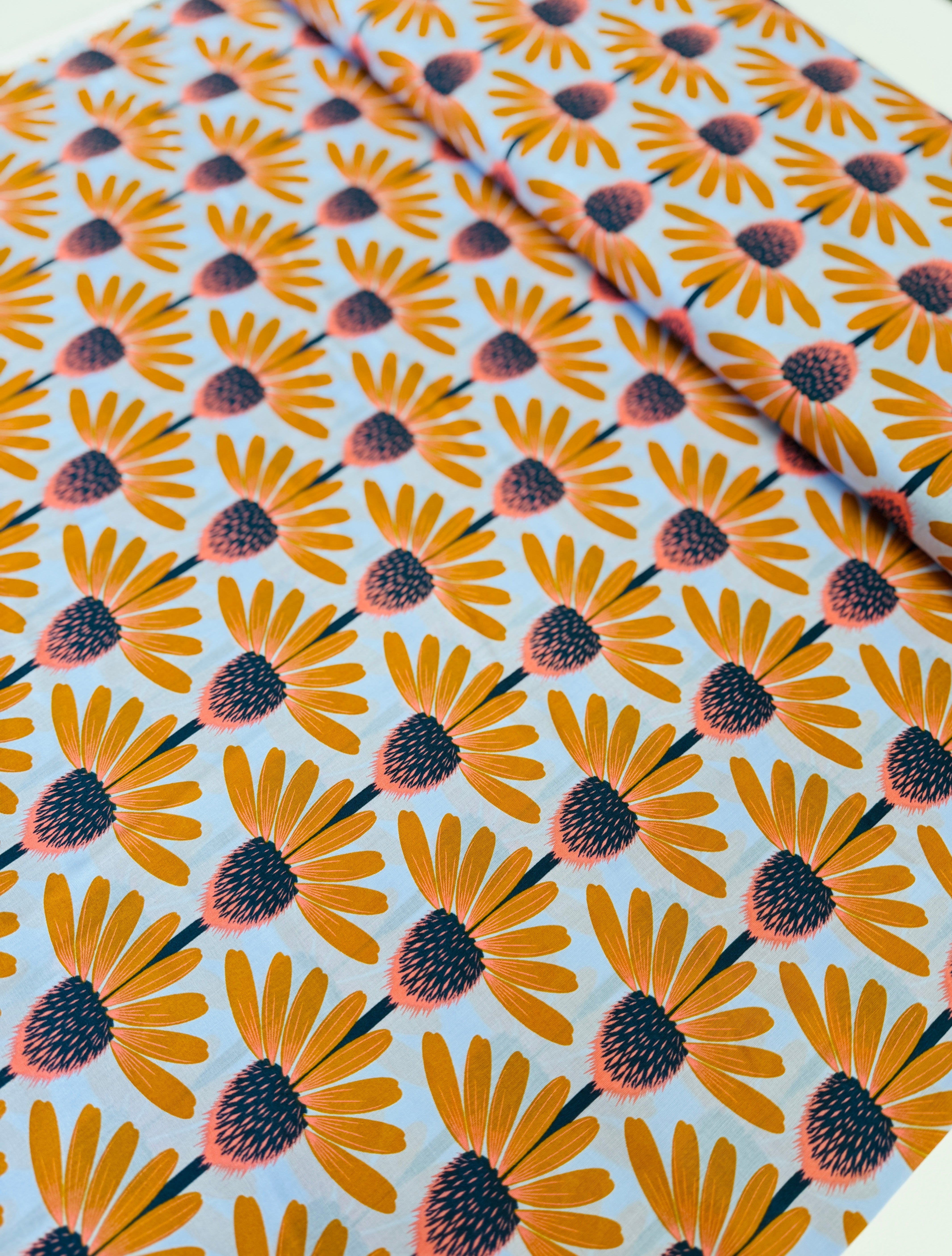 Love Always AM – Echinacea Morning Cotton Lawn by Anna Maria Horner featuring large yellow and coral echinacea flowers on a sky blue background.