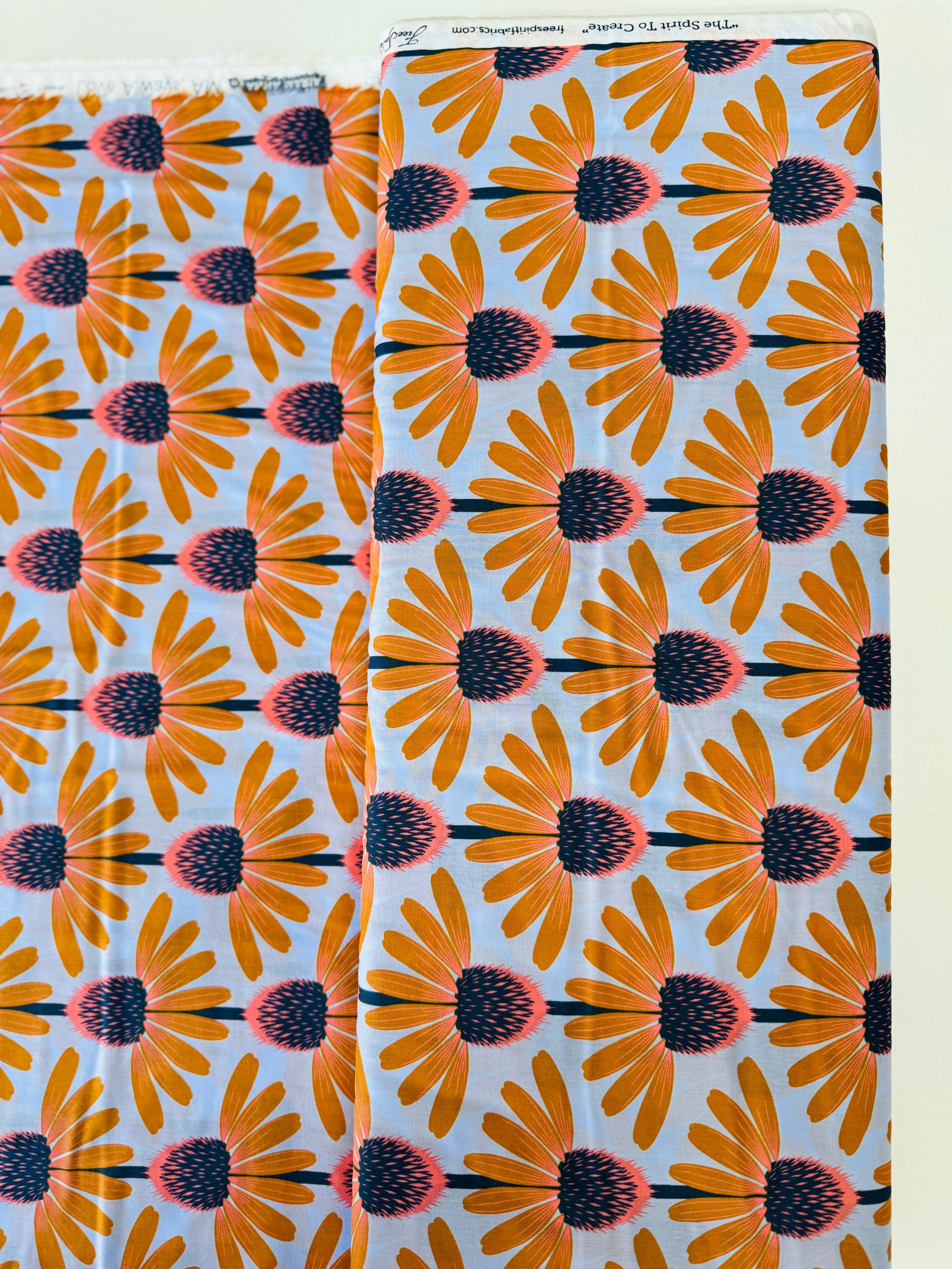 Love Always AM – Echinacea Morning Cotton Lawn by Anna Maria Horner featuring large yellow and coral echinacea flowers on a sky blue background.