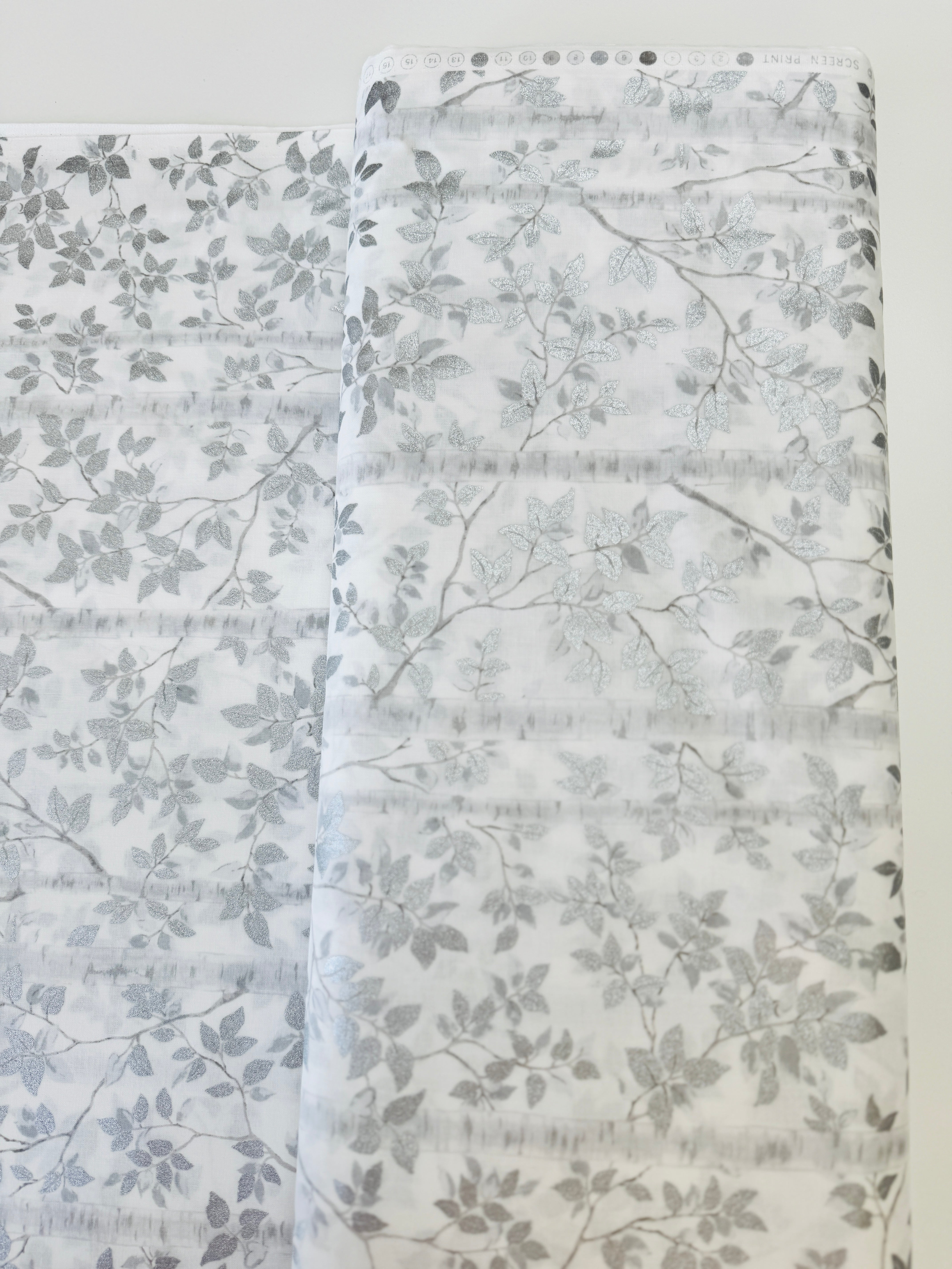 First Snowfall fabric with silver metallic leaves on white background by Hoffman Fabrics – quilting and holiday cotton.