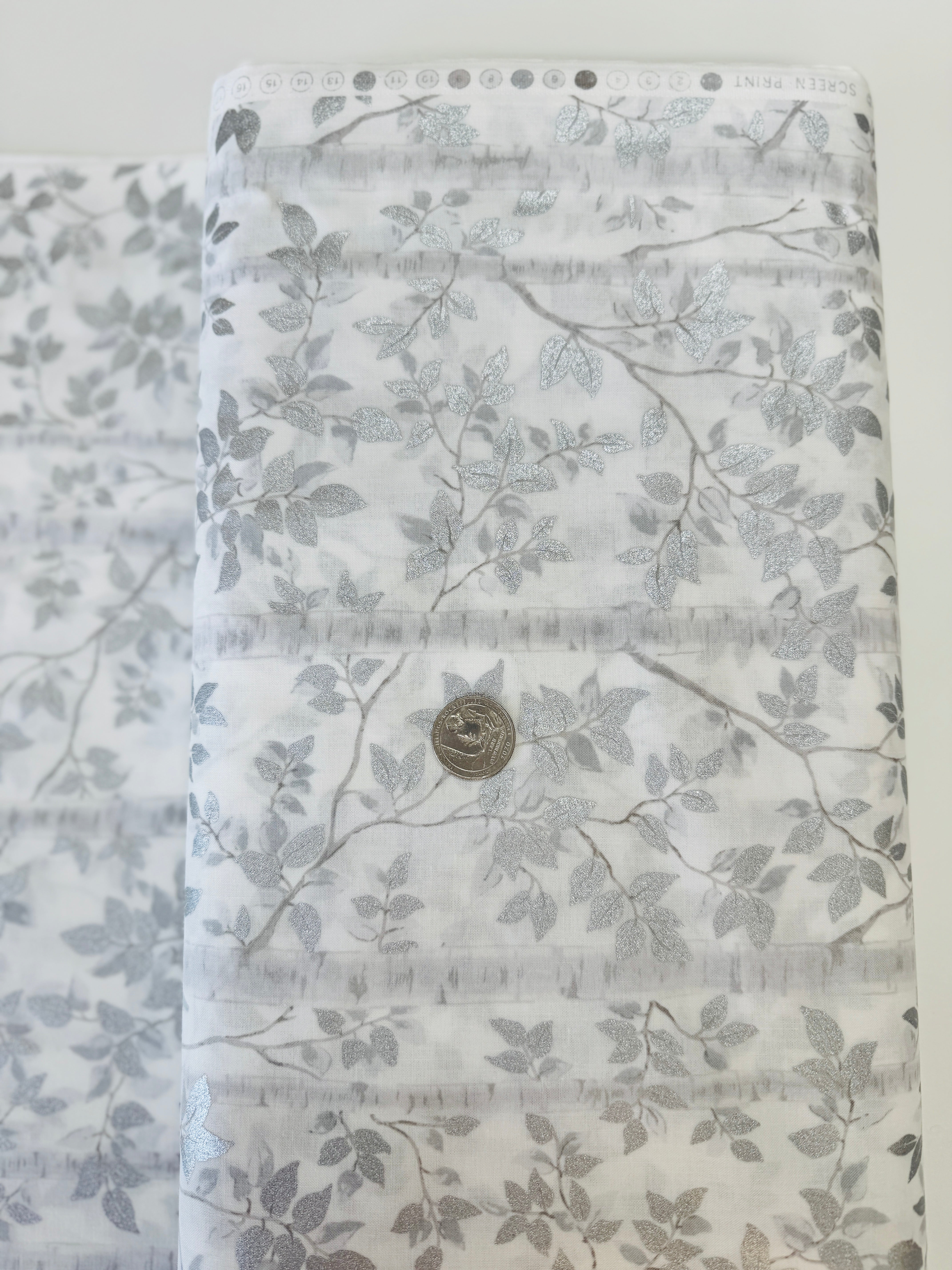 First Snowfall fabric with silver metallic leaves on white background by Hoffman Fabrics – quilting and holiday cotton.