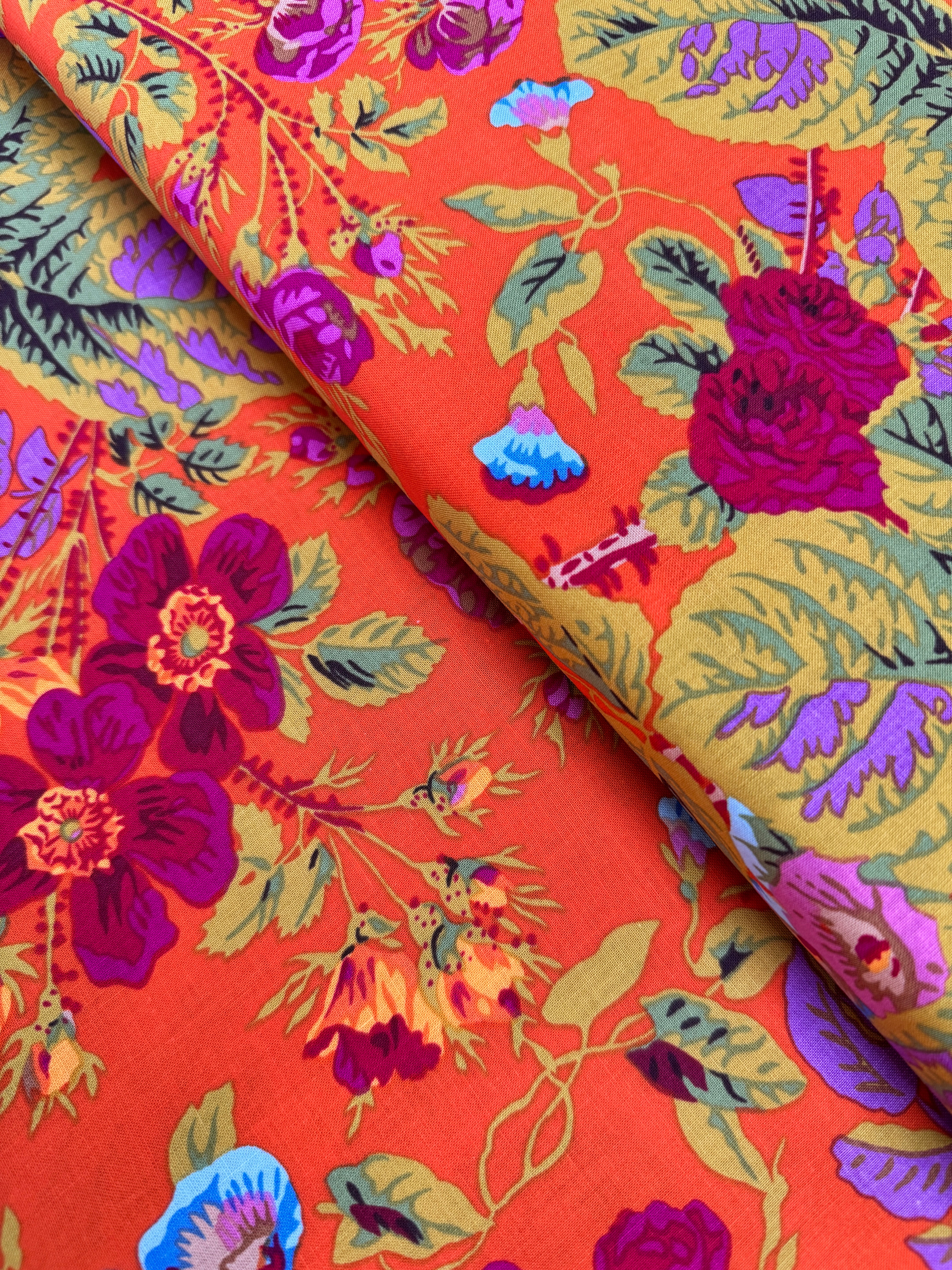 Kaffe Fassett Collective Gradi Floral Tomato fabric by Philip Jacobs for Free Spirit Fabrics featuring large bold floral blooms in pink and purple on a red background.