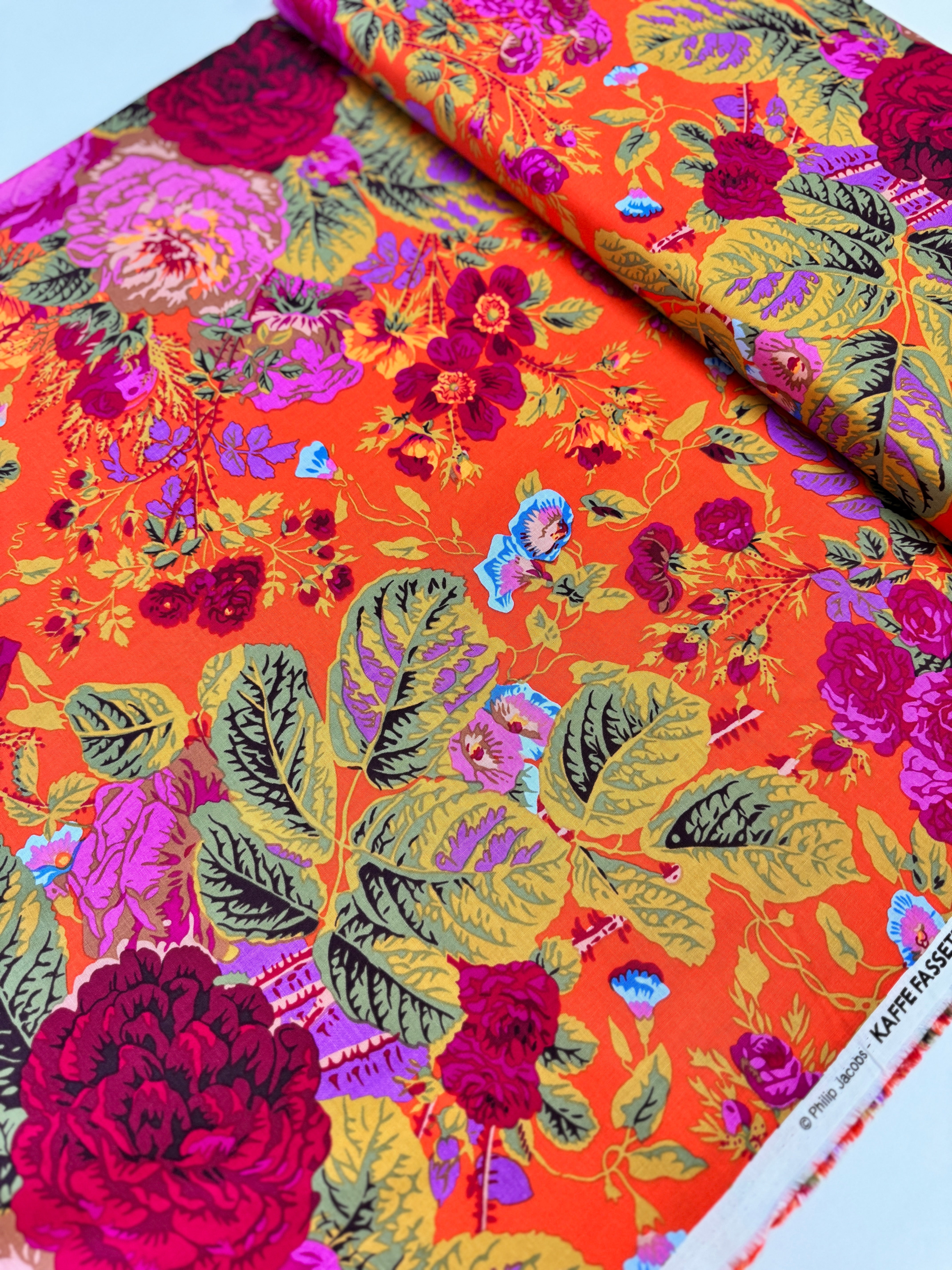Kaffe Fassett Collective Gradi Floral Tomato fabric by Philip Jacobs for Free Spirit Fabrics featuring large bold floral blooms in pink and purple on a red background.
