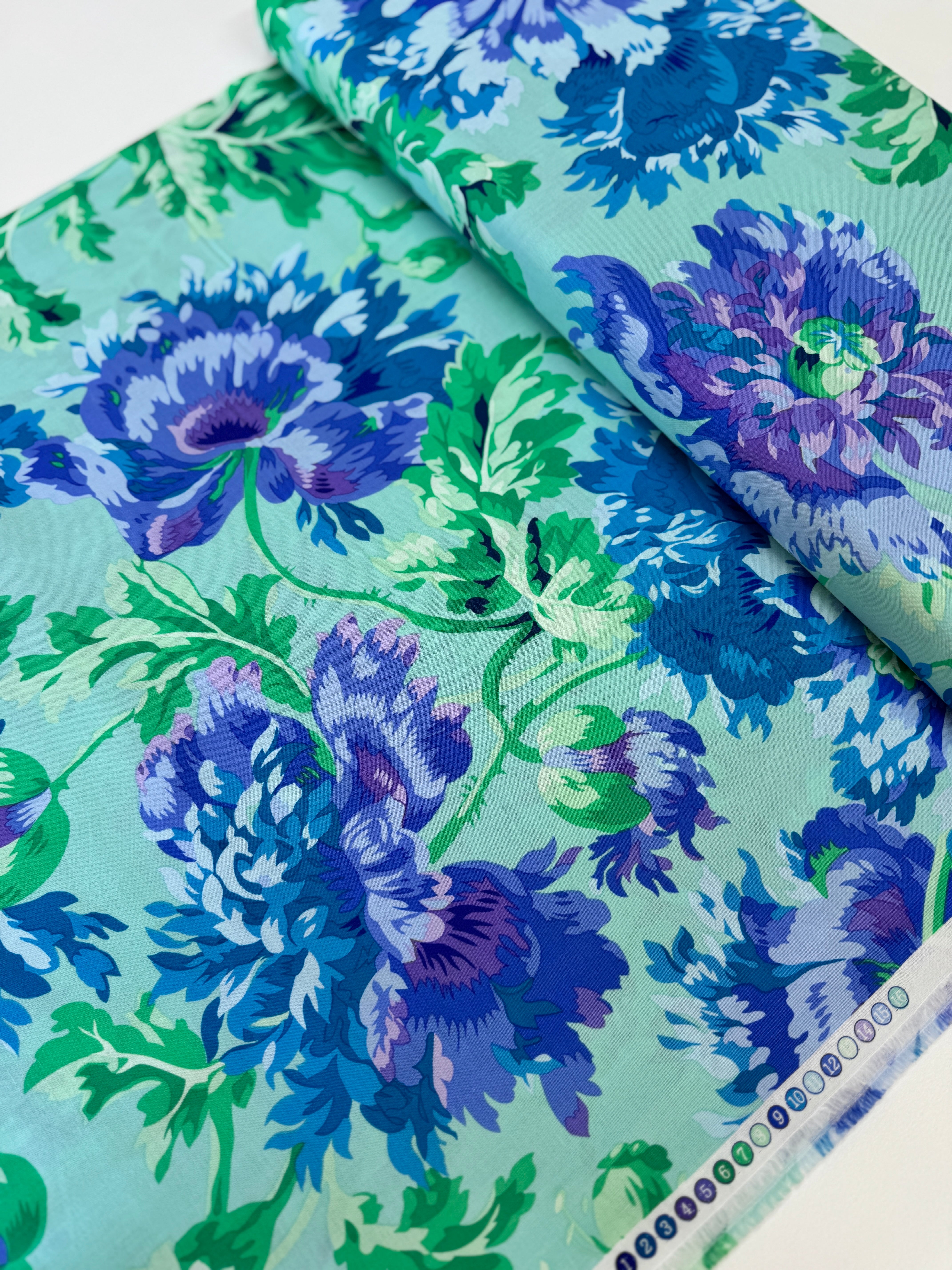 Kaffe Fassett Collective Garden Party Celadon fabric by Philip Jacobs for Free Spirit Fabrics featuring large blue and purple floral blooms with green leaves on a celadon background.