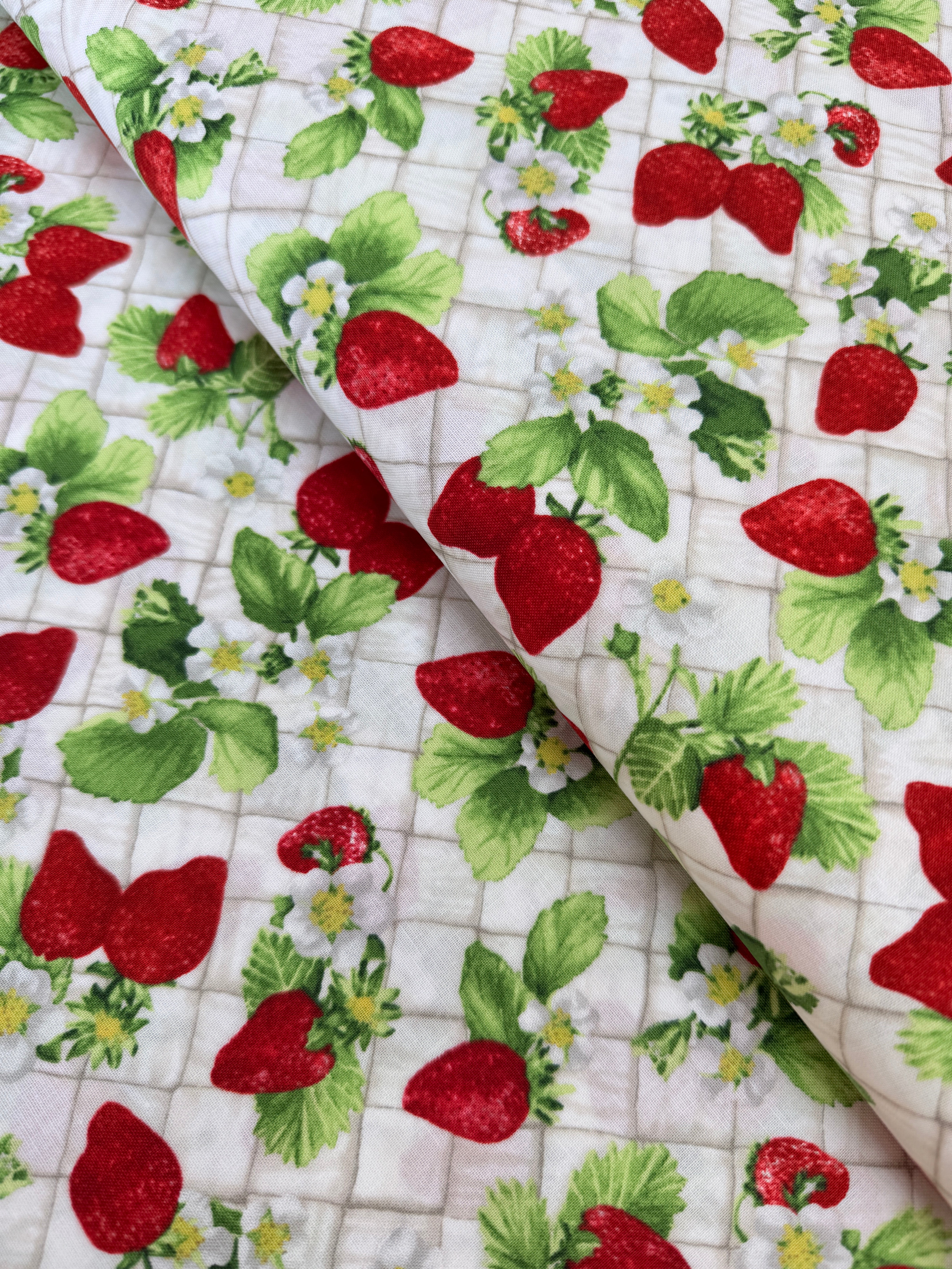 Ambrosia Farm Berry Picking Natural fabric by RJR Studio for RJR Fabrics featuring red strawberries, green leaves, and white flowers on a cream grid background.