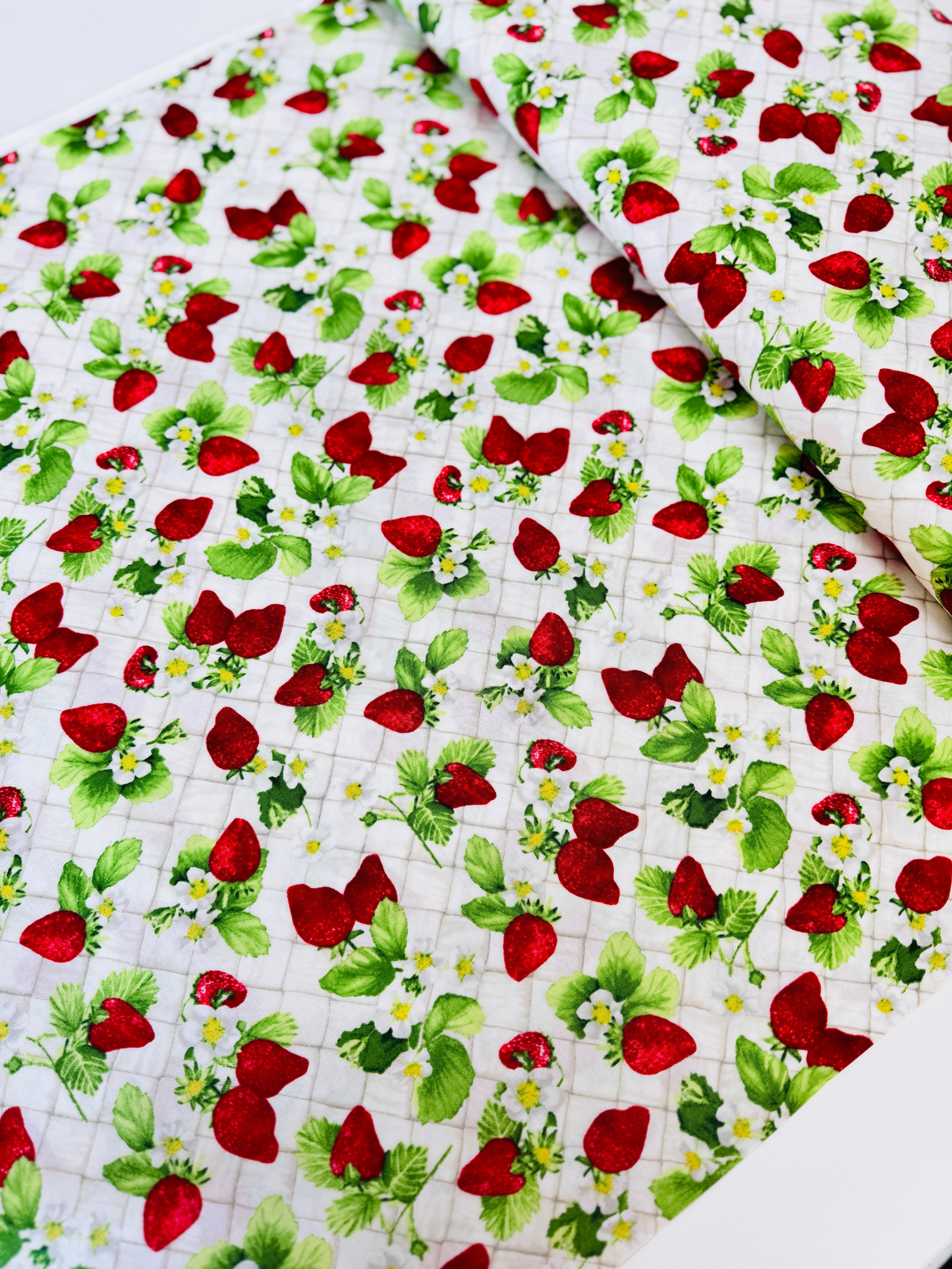 Ambrosia Farm Berry Picking Natural fabric by RJR Studio for RJR Fabrics featuring red strawberries, green leaves, and white flowers on a cream grid background.
