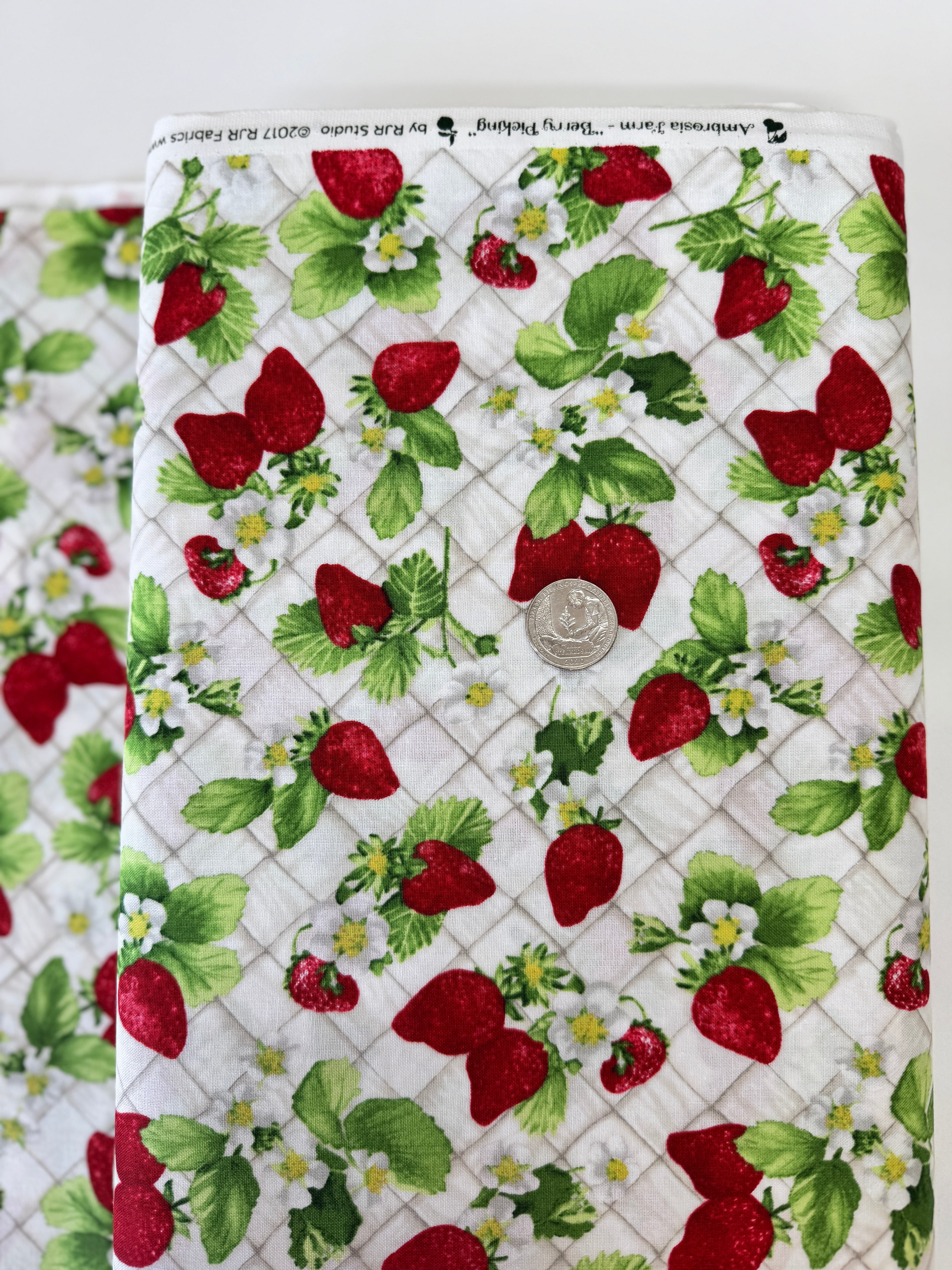 Ambrosia Farm Berry Picking Natural fabric by RJR Studio for RJR Fabrics featuring red strawberries, green leaves, and white flowers on a cream grid background.