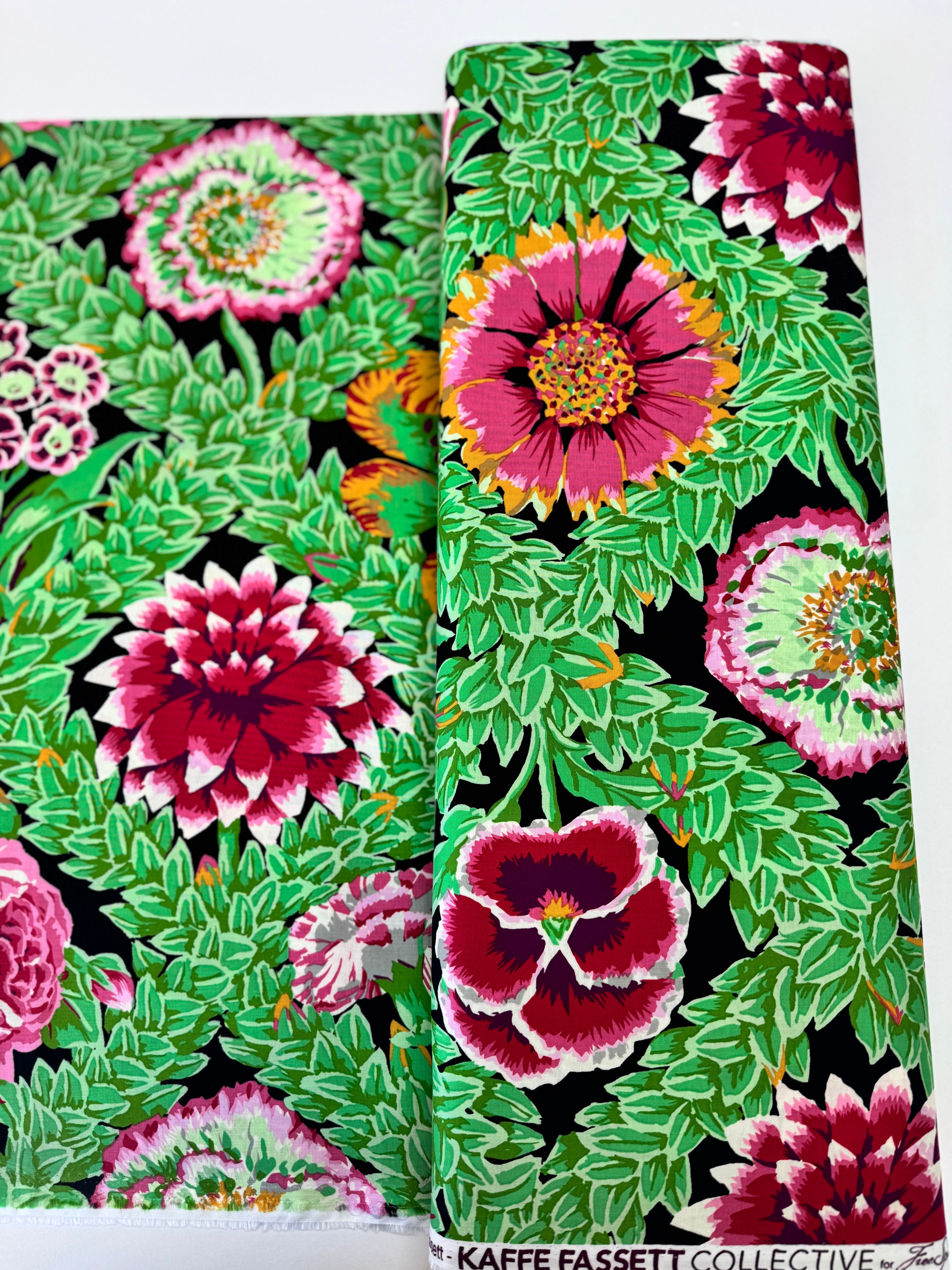 Kaffe Fassett Collective Vintage Flower Lattice Jewel fabric by Philip Jacobs for Free Spirit Fabrics featuring bold pink and green floral pattern on black background.