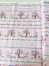 A pastel pink cotton fabric featuring rows of playful deer, white bunnies, trees, and flowers in a stripe pattern - Storybook Forest - Bunnies & Deer Stripe by Timeless Treasures.