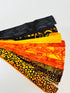 Assorted Halloween batik scrap strip bundle in orange, black, and gold tones, 2-inch strips by Island Batik.