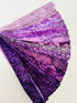 Assorted purple batik fabric strips fanned out, featuring 21 lavender to deep violet 2-inch strips by Kathy Engle for Island Batik.