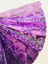 Assorted purple batik fabric strips fanned out, featuring 21 lavender to deep violet 2-inch strips by Kathy Engle for Island Batik.