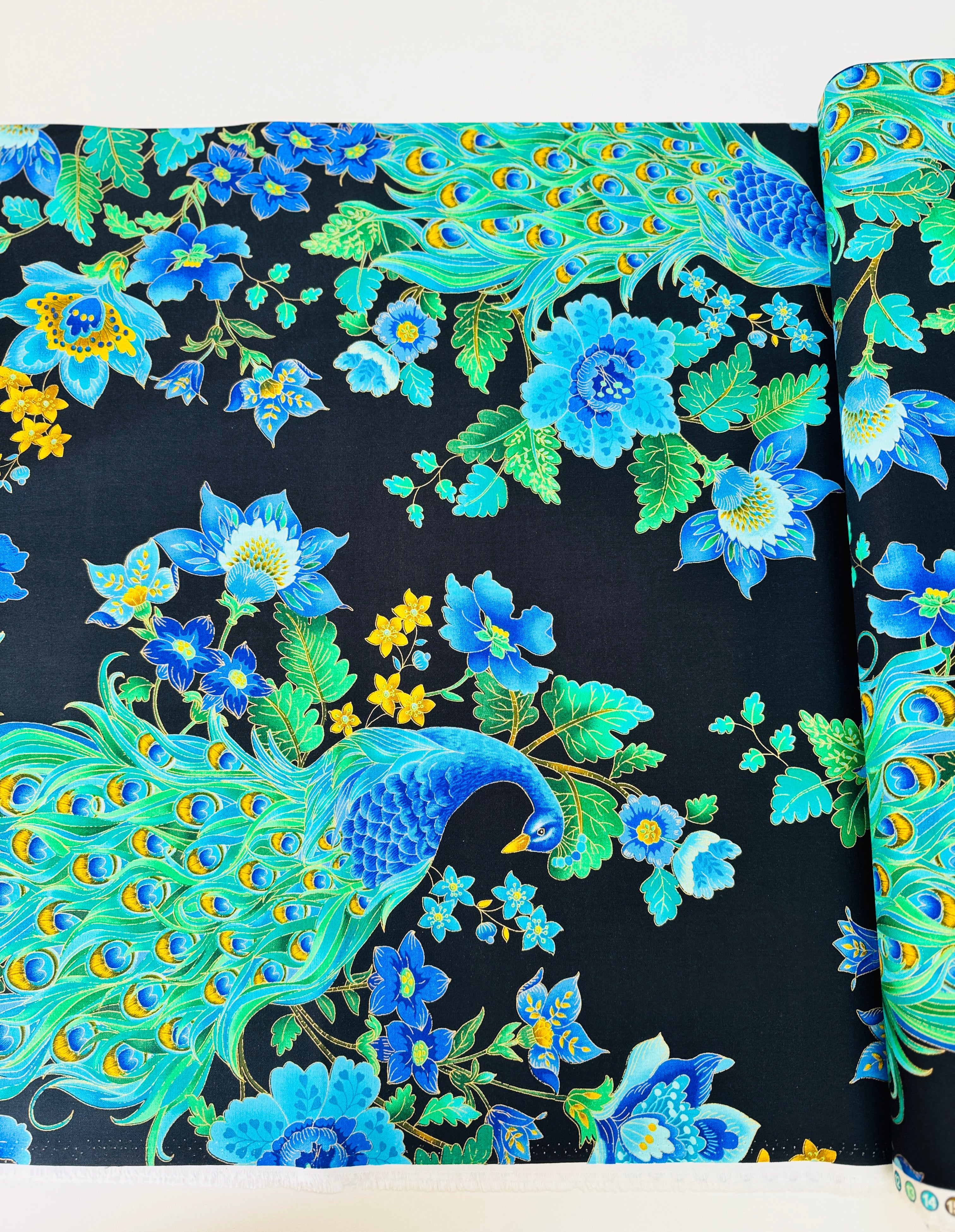 Peacock metallic cotton fabric on black background with gold accents by Timeless Treasures