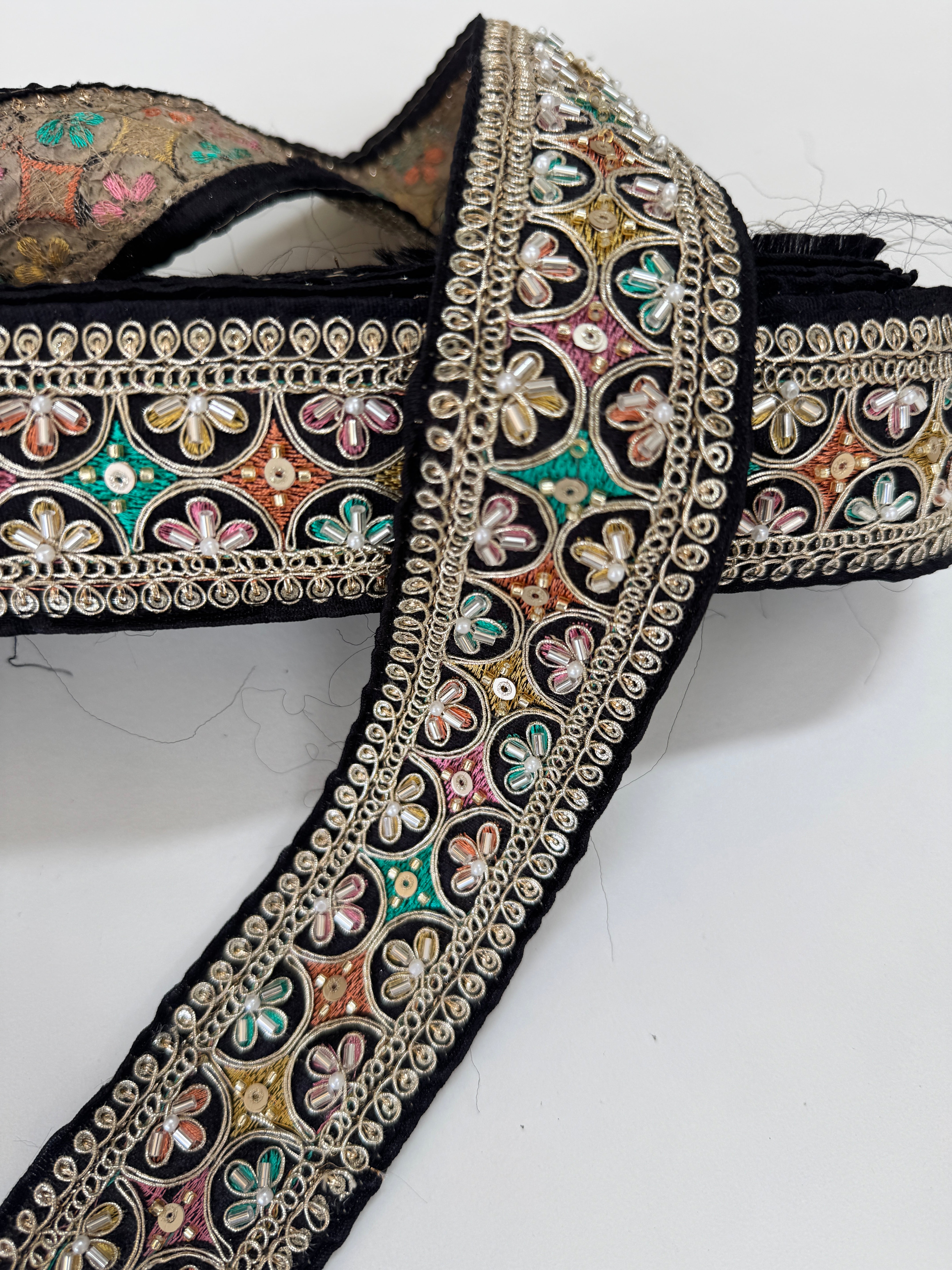 Multicolor embroidered trim on black with beads, sequins, and metallic thread detailing for lehengas, sarees, dupattas, costumes, accessories, and sewing projects.