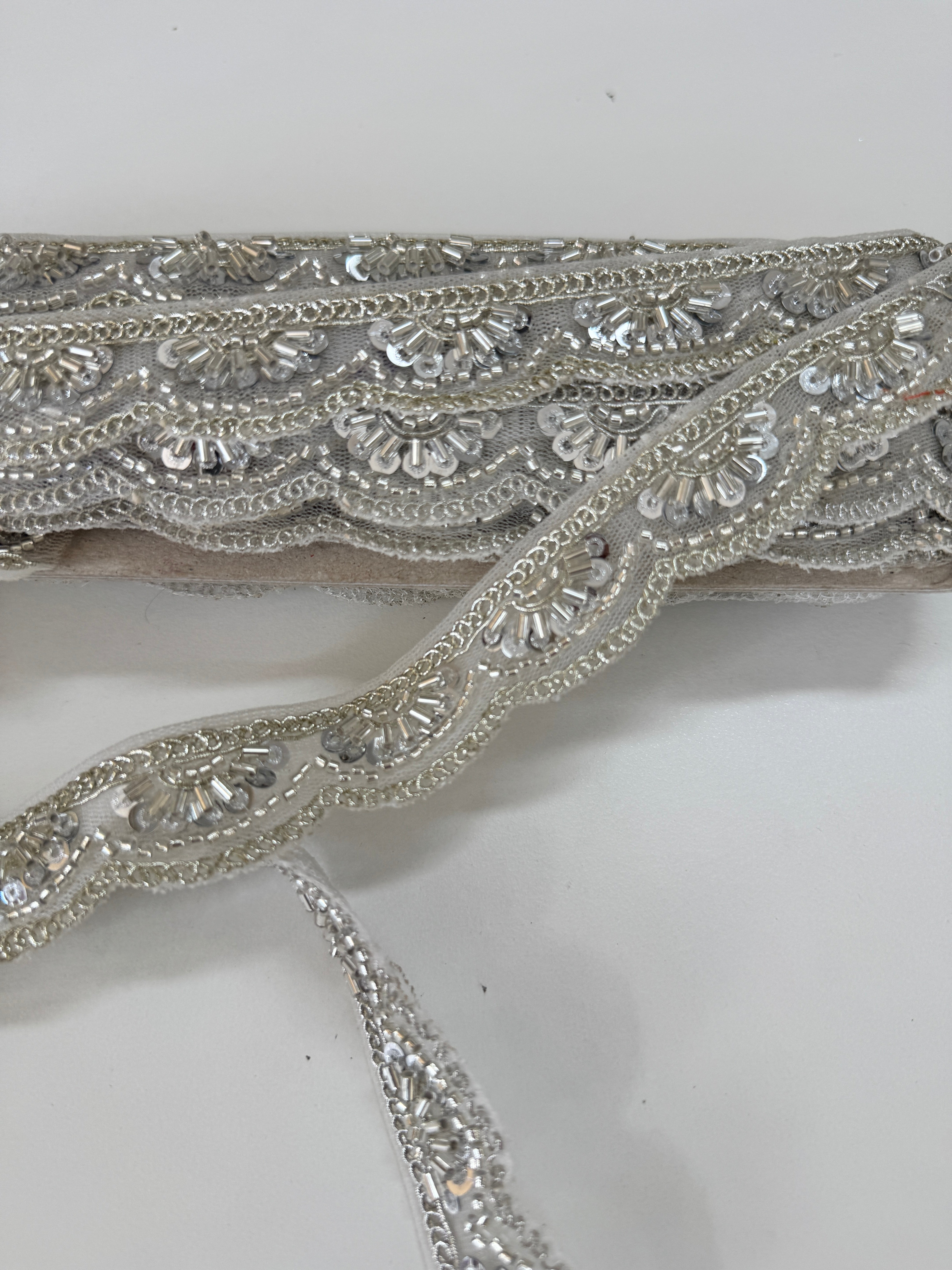 Silver beaded lace trim with sequins, embroidery, and scalloped edge for bridal gowns, veils, lehengas, sarees, couture garments, and sewing projects.