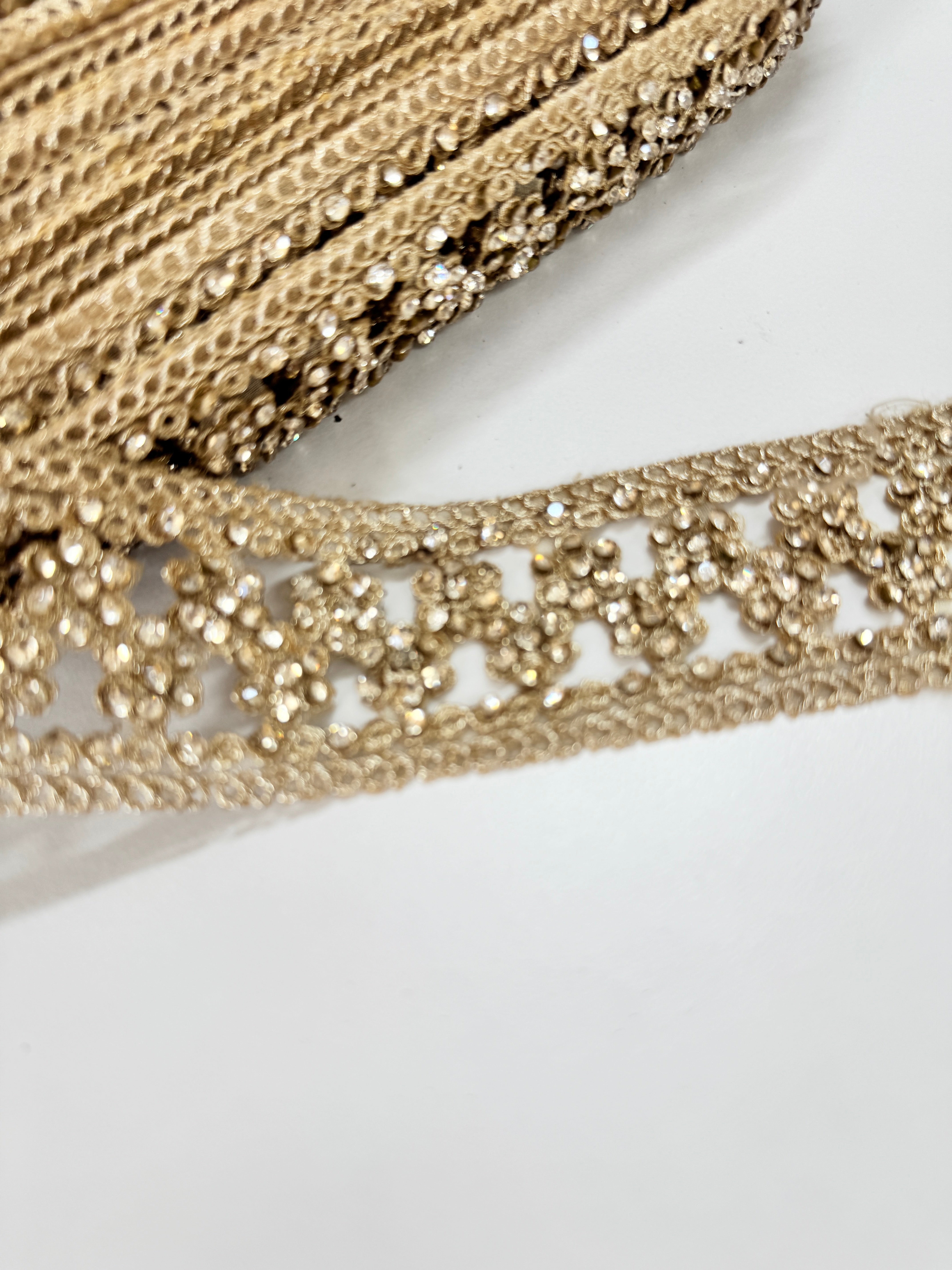 Champagne beaded lace trim with crystal embellishments and embroidered openwork design for bridal gowns, veils, lehengas, sarees, and couture sewing projects.