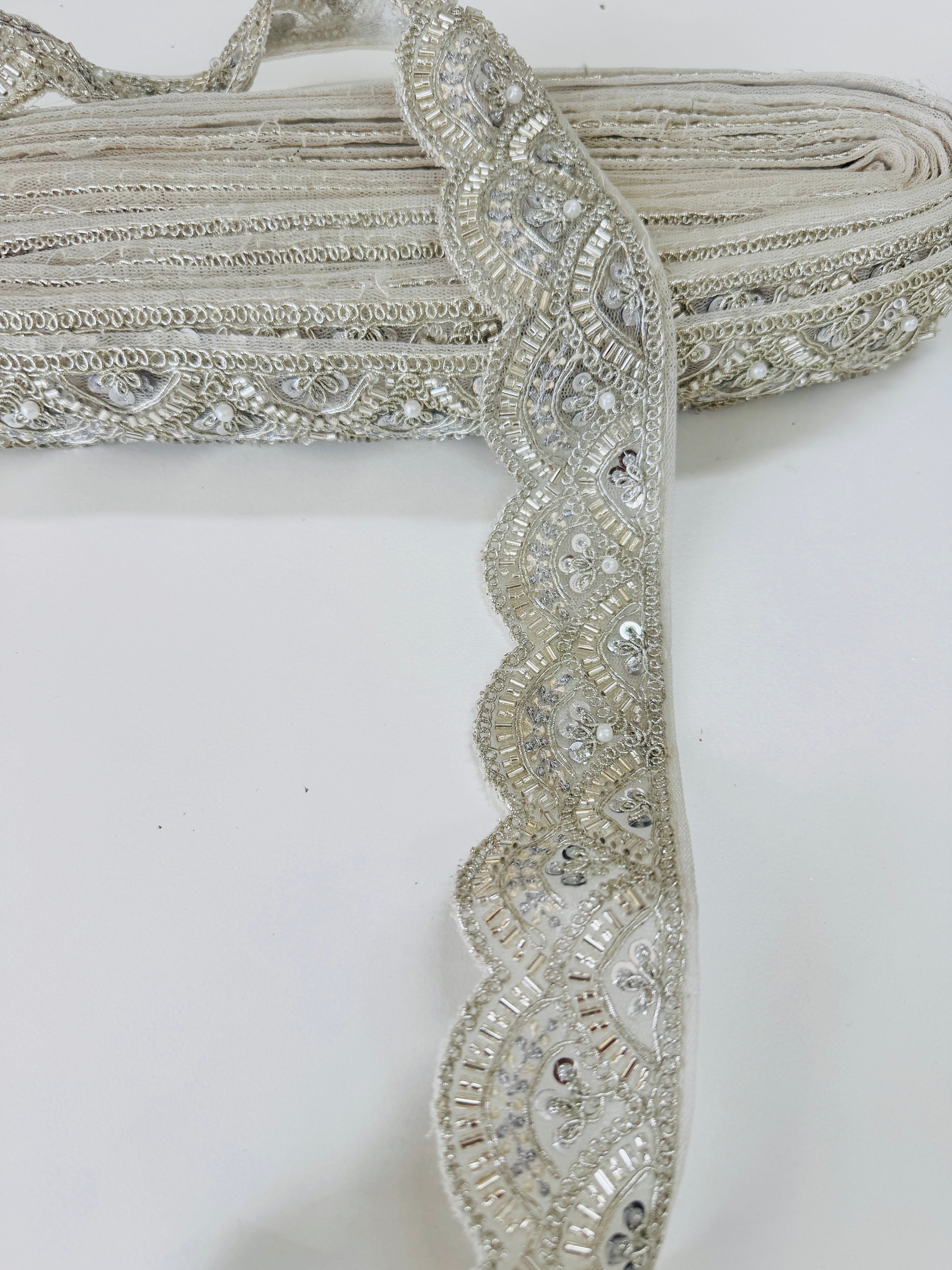 Ivory pearl beaded scalloped lace trim with intricate embroidery, sequins, and pearl embellishments for bridal gowns, veils, sarees, lehengas, christening dresses, and couture sewing projects.