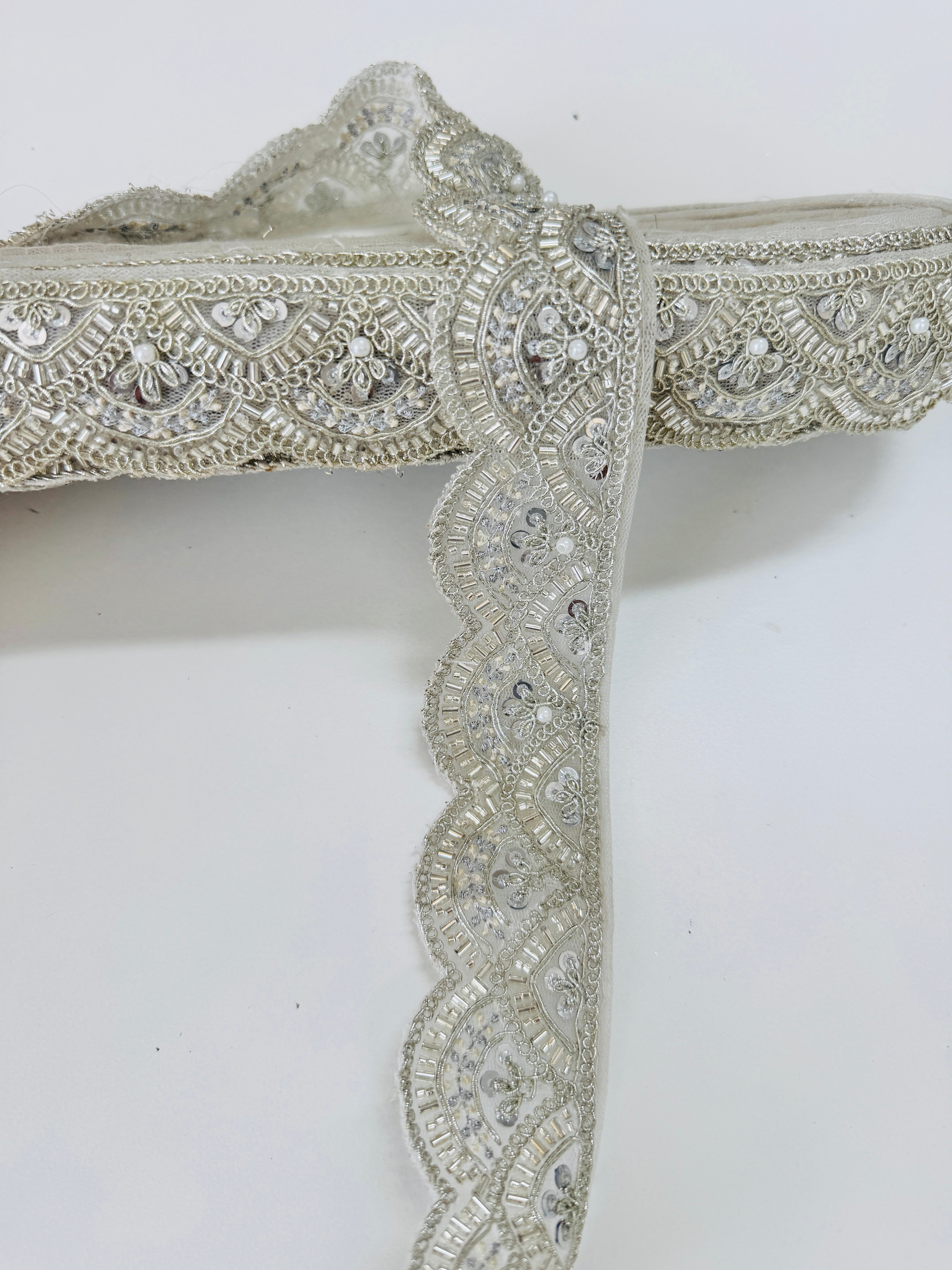 Ivory pearl beaded scalloped lace trim with intricate embroidery, sequins, and pearl embellishments for bridal gowns, veils, sarees, lehengas, christening dresses, and couture sewing projects.